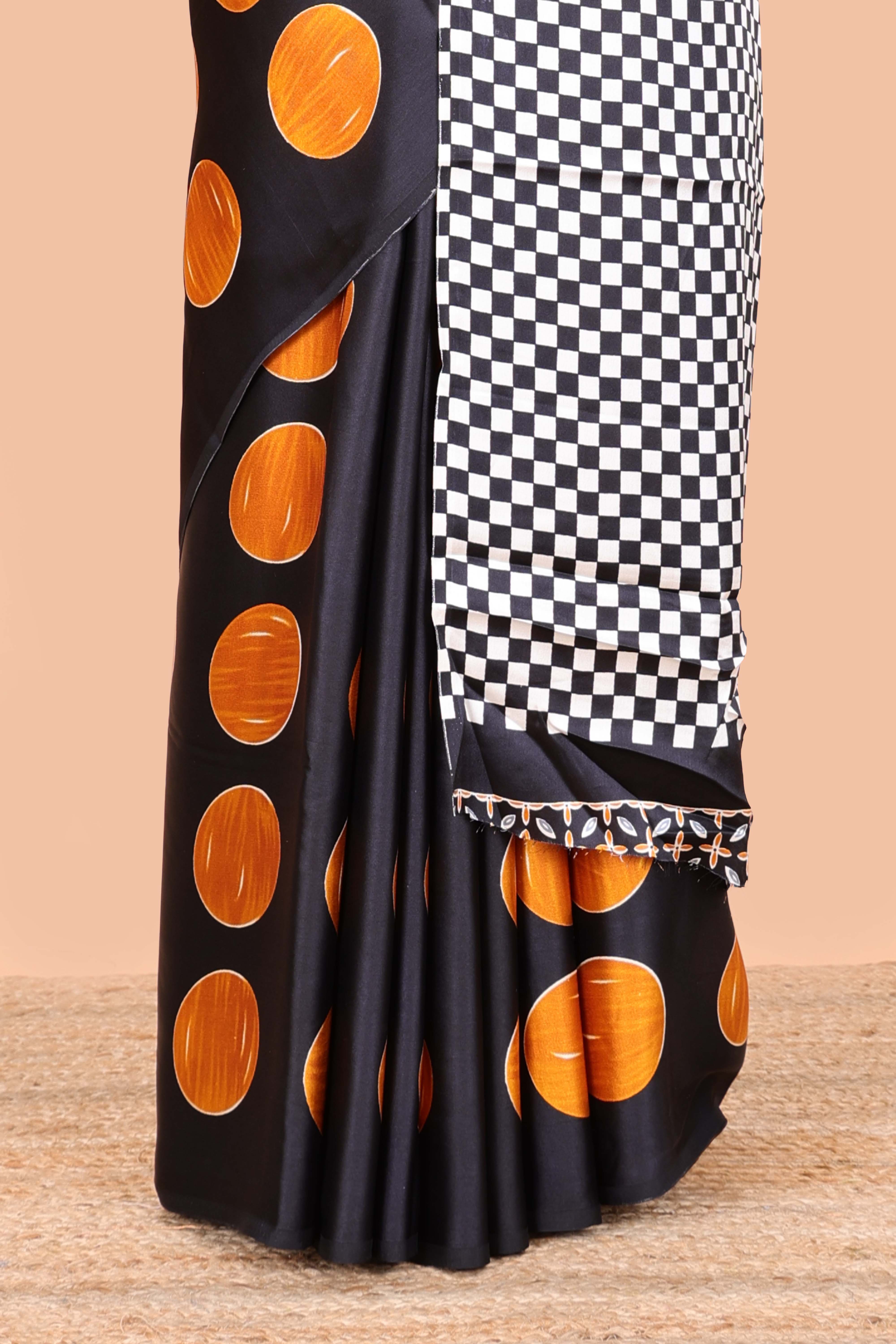 Black satin modal saree with orange polka print, contrast checked pallu, and printed blouse