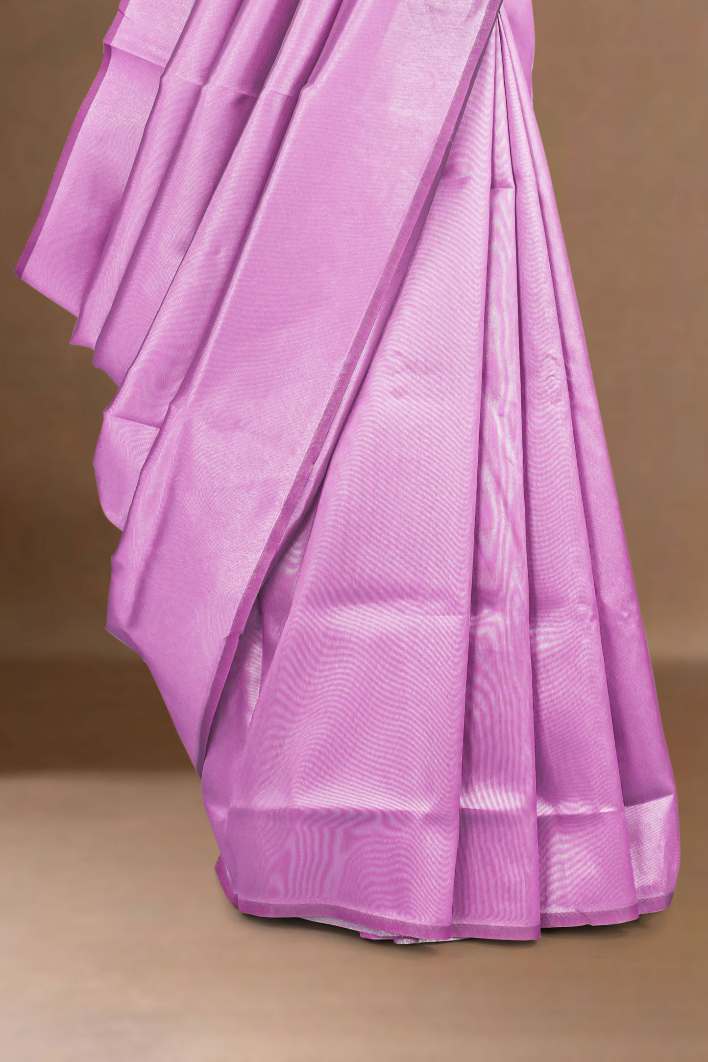 Lavender lichi silk saree with a subtle pattern on a brown background
