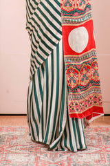 White Modal Silk Saree Detailing Vertical Green Stripes That Add a Sleek and Elegant Touch. Highlighted Contrast Ajrakh Print Pallu Along With Blouse