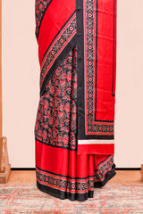 Black Modal Silk Saree The Body Has Ajrakh Design The Pallu Are Highlighted Vibrant Red Colour Along With Blouse
