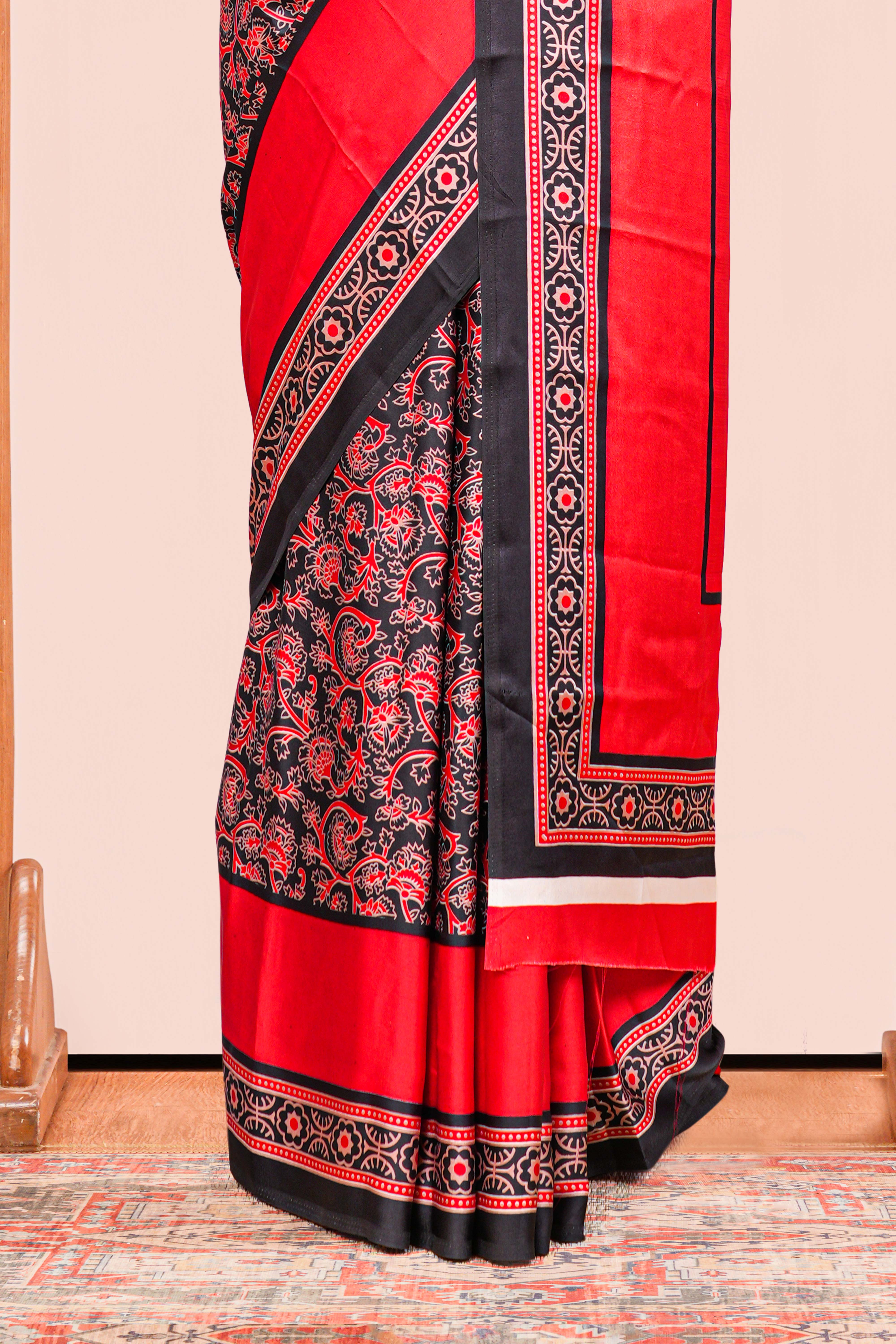Black Modal Silk Saree The Body Has Ajrakh Design The Pallu Are Highlighted Vibrant Red Colour Along With Blouse