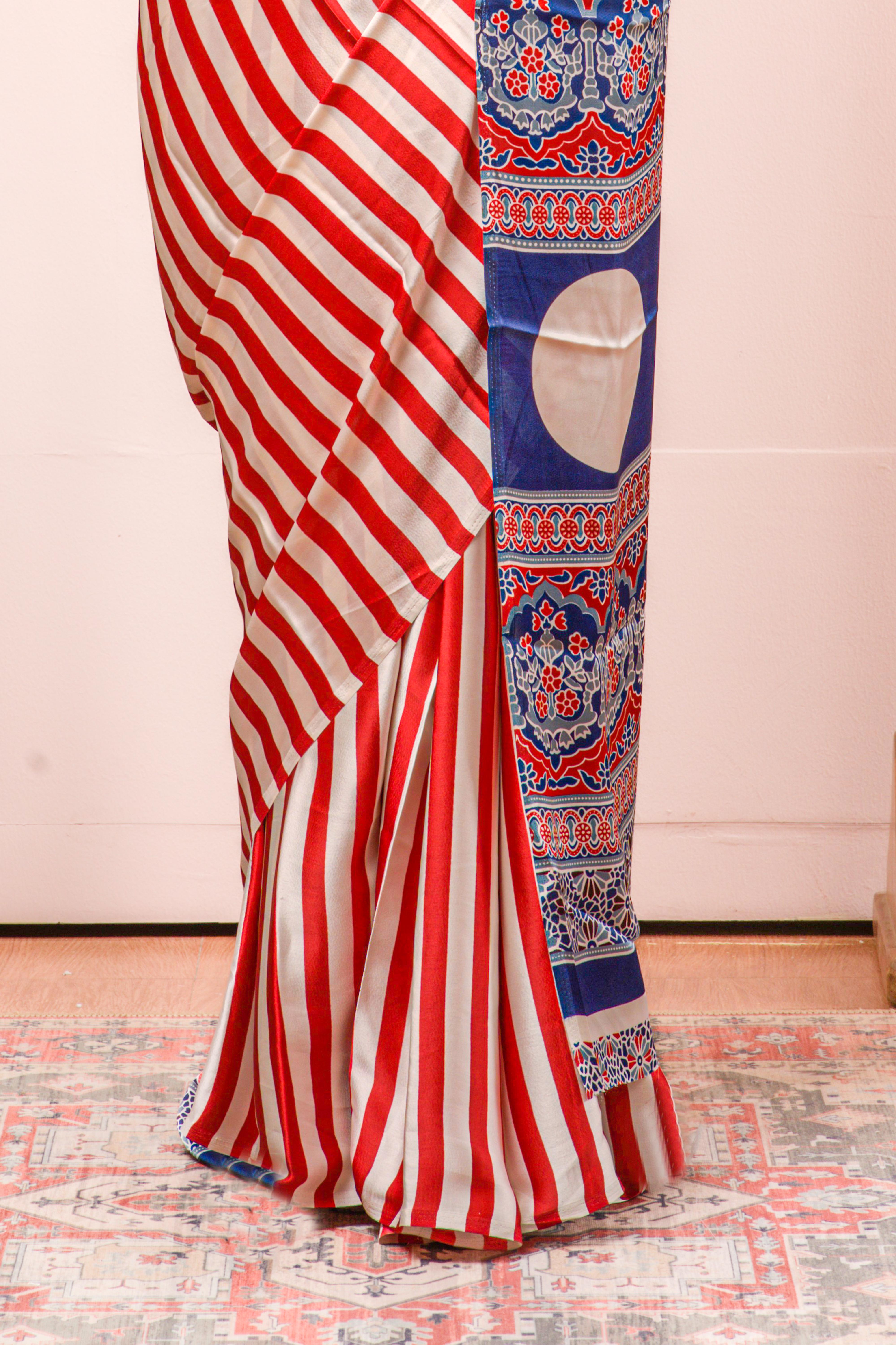 White Modal Silk Saree Body Detailing Contrast Red Vertical Stripes That Add a Sleek and Elegant Touch. The Pallu Are Highlighted Ajrakh Design Along With Blouse