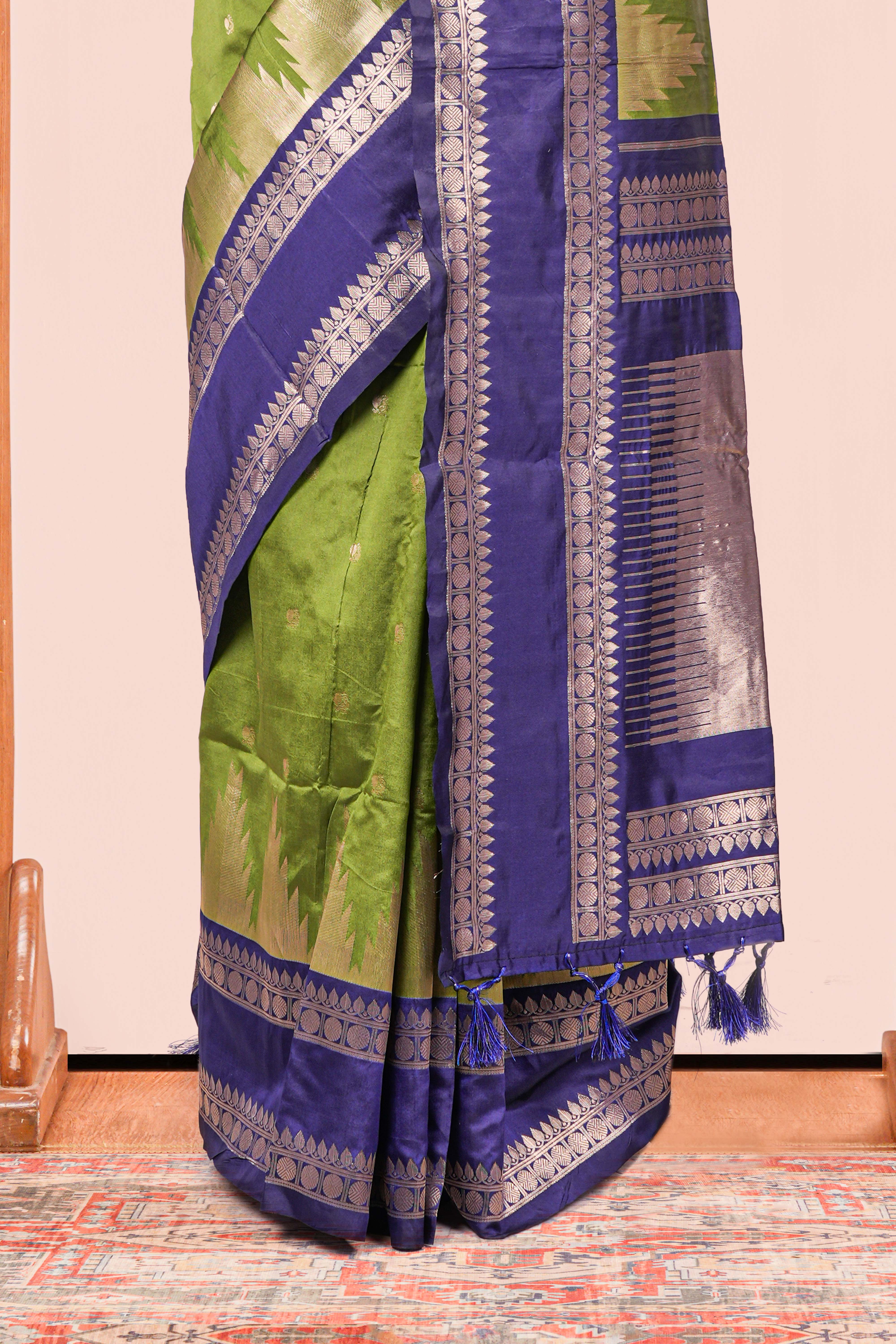 Green Semi Art Silk Saree Delicate Golden Zari Motifs Along With Thalampoo Zari Woven Across The Body. The Border Is Broad With Intricate Floral Zari Weaving Rich Golden Zari Pallu