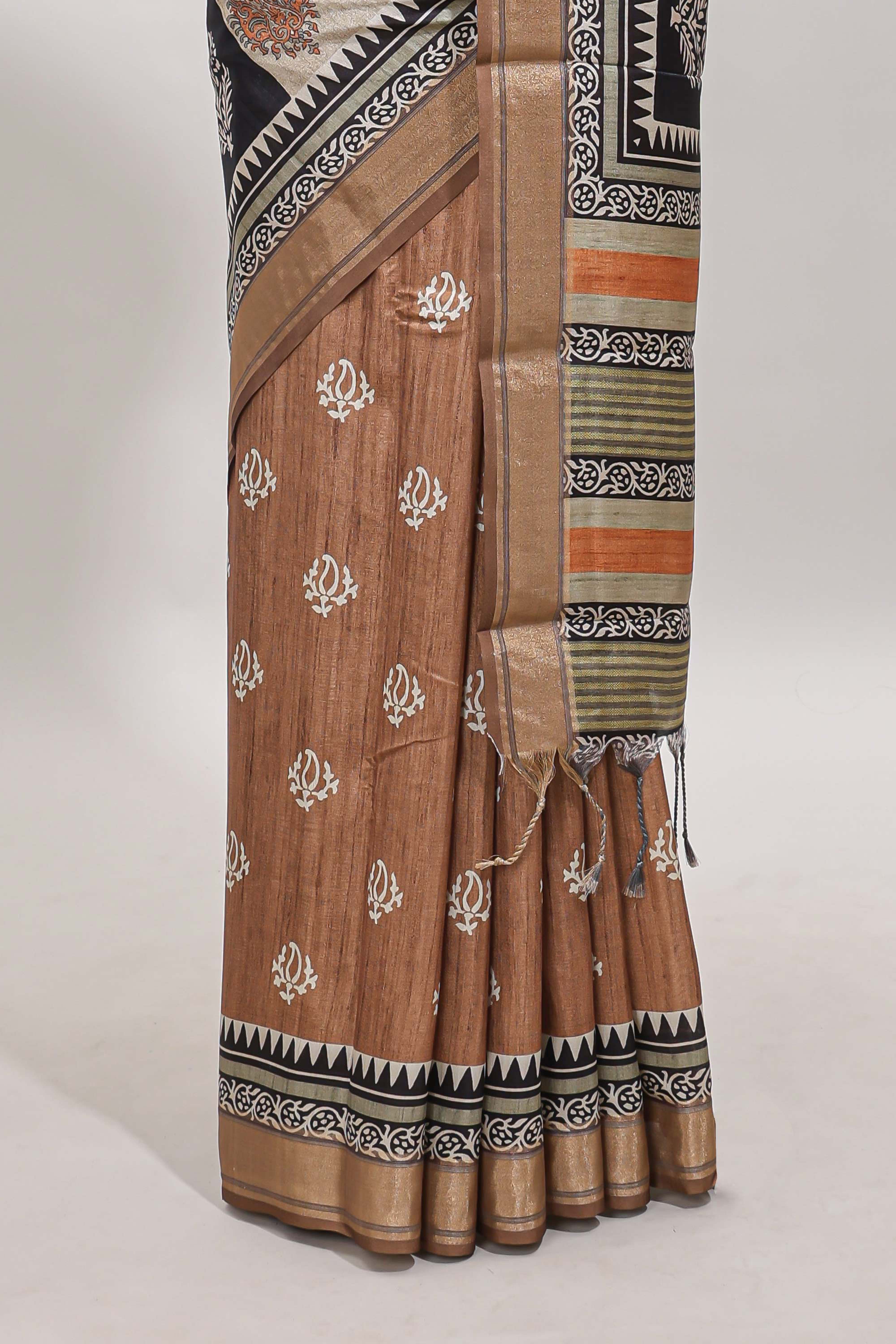 Elegant Tussar Saree with an earthy brown body ethnic prints intricate borders and tassel finished pallu along with contrast blouse