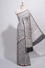 Grey colour Assam Silk saree traditional folk motif print floral patterns and a contrast woven border The detailed pallu along with contrast blouse
