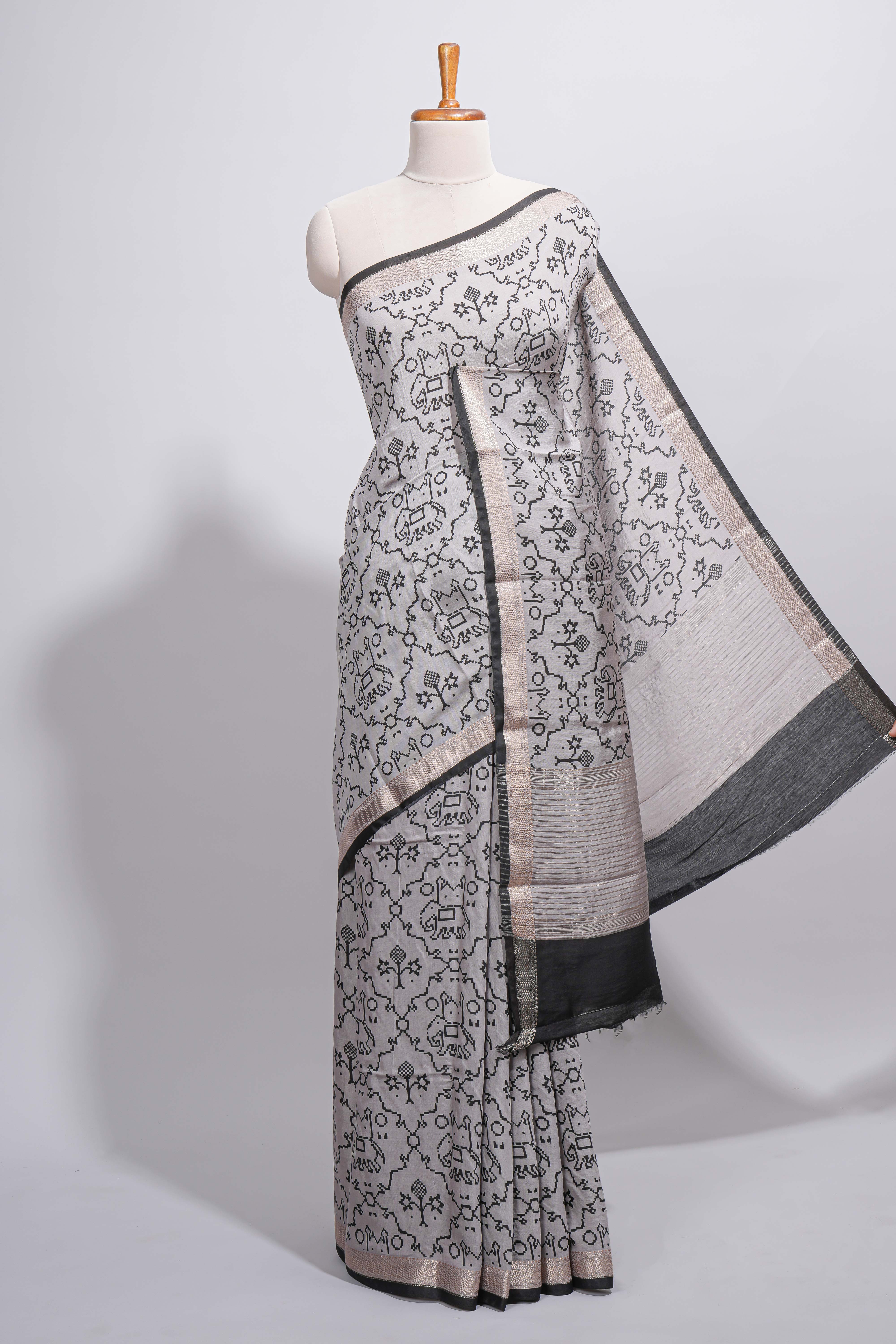 Grey colour Assam Silk saree traditional folk motif print floral patterns and a contrast woven border The detailed pallu along with contrast blouse