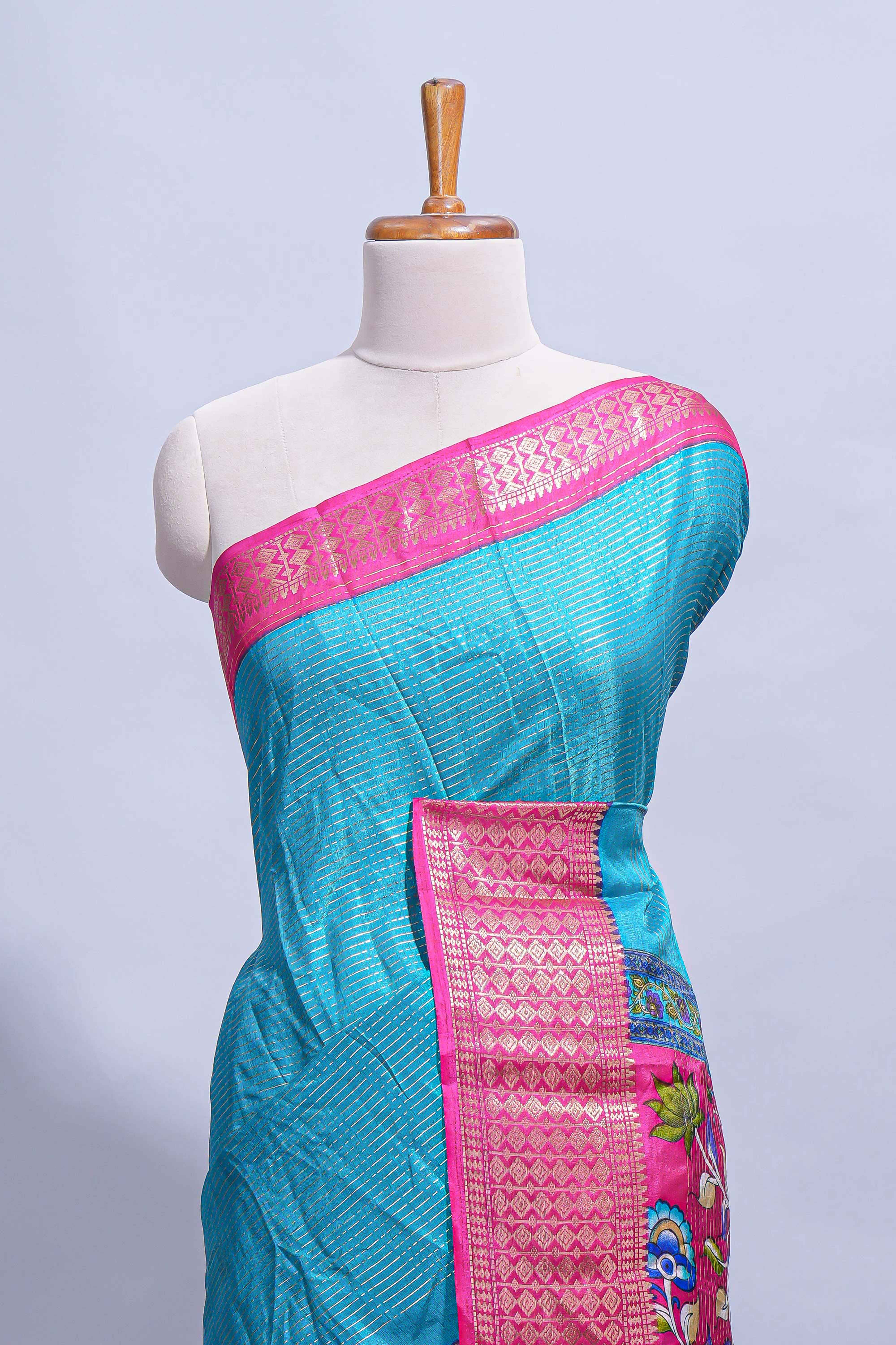 Turquoise blue dola silk saree with fine zari stripes contrastzari border and a rich peacock floral woven pallu along with printed contrast blouse