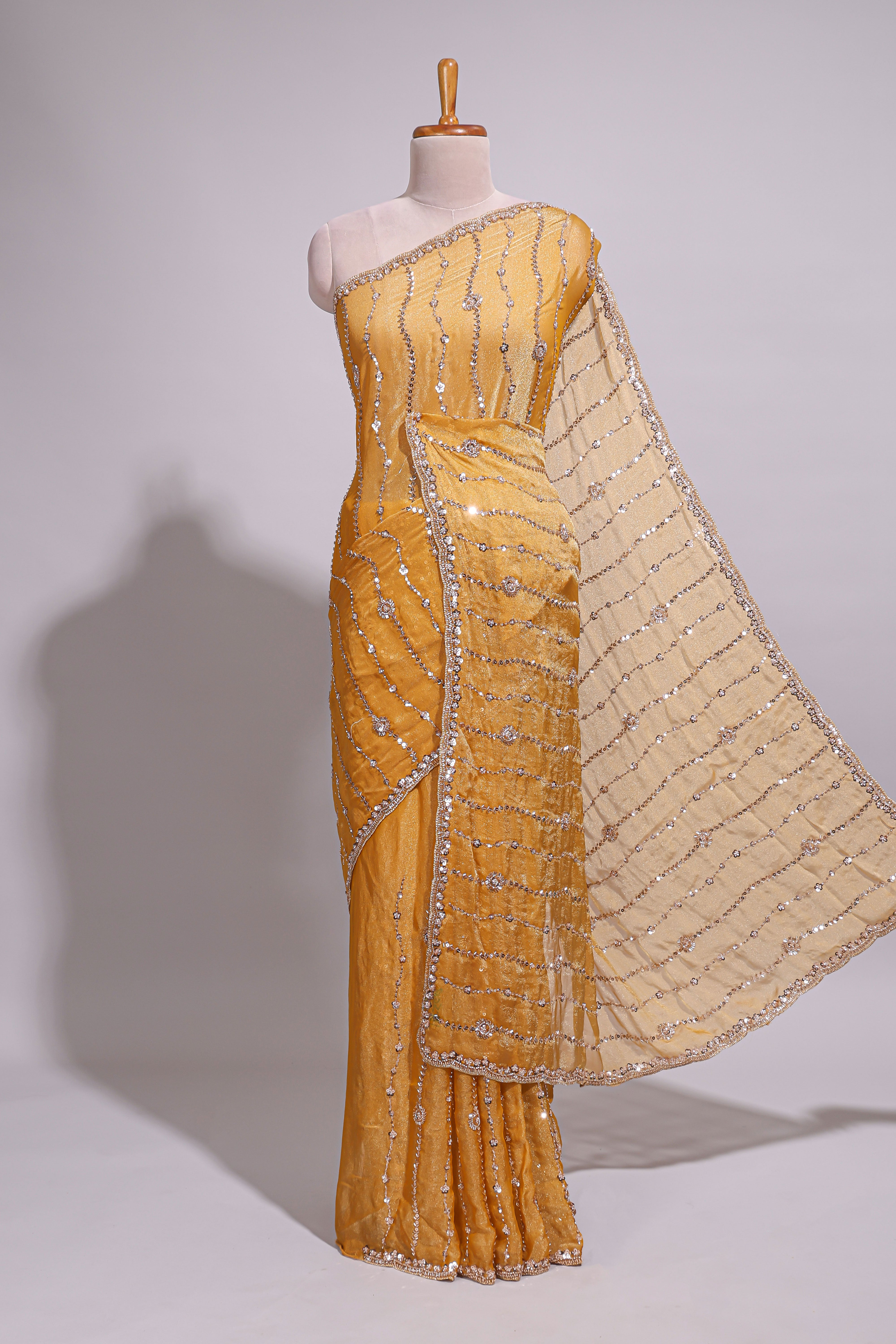 Mustard yellow saree with elegant sequin embellishments and a shimmering border along with matching blouse