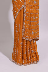 Orange saree with elegant sequin embellishments and a shimmering border along with embroidered blouse piece
