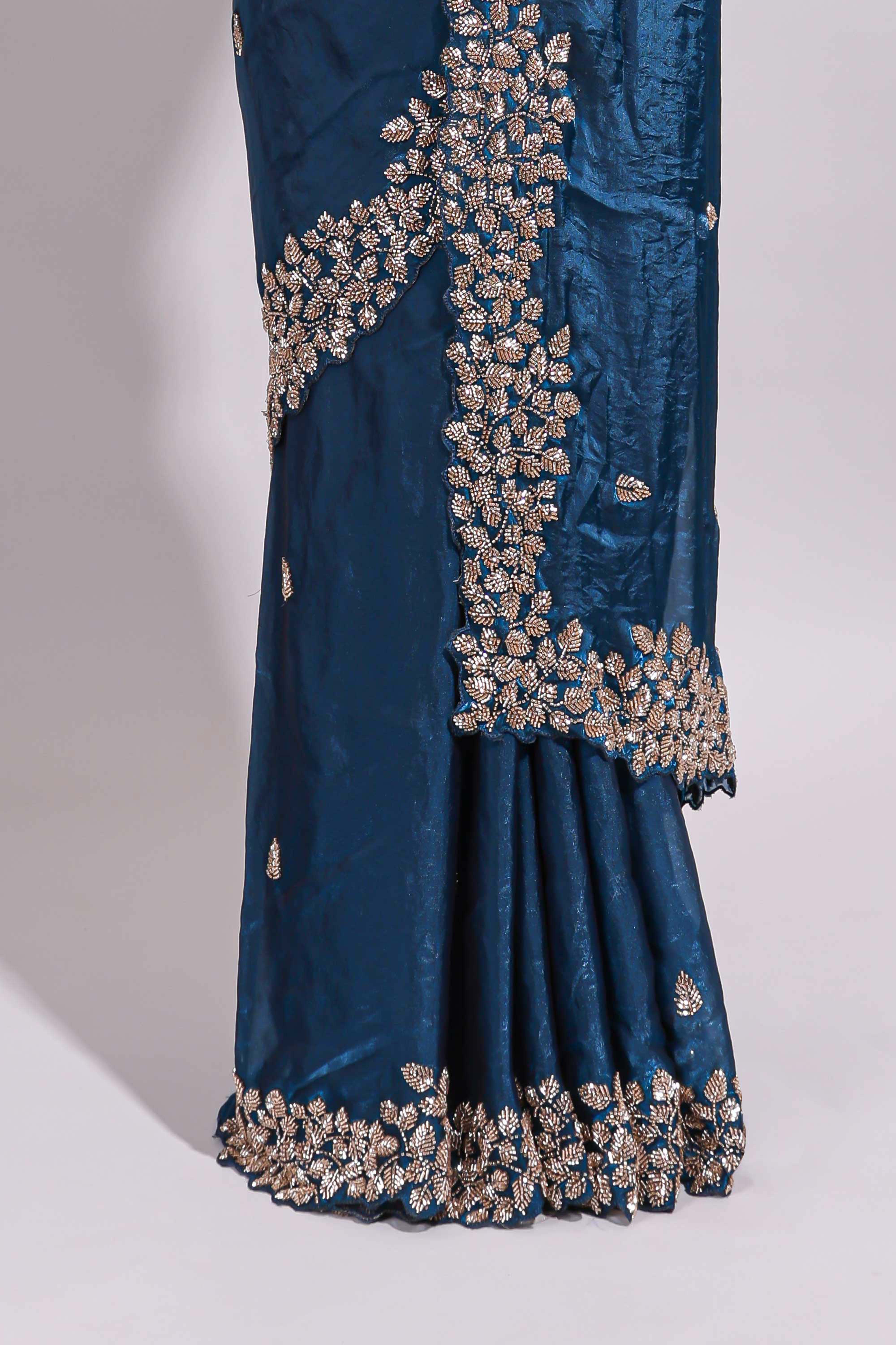 Royal blue saree with elegant golden floral embroidery and a rich embellished border along with embroidered blouse piece