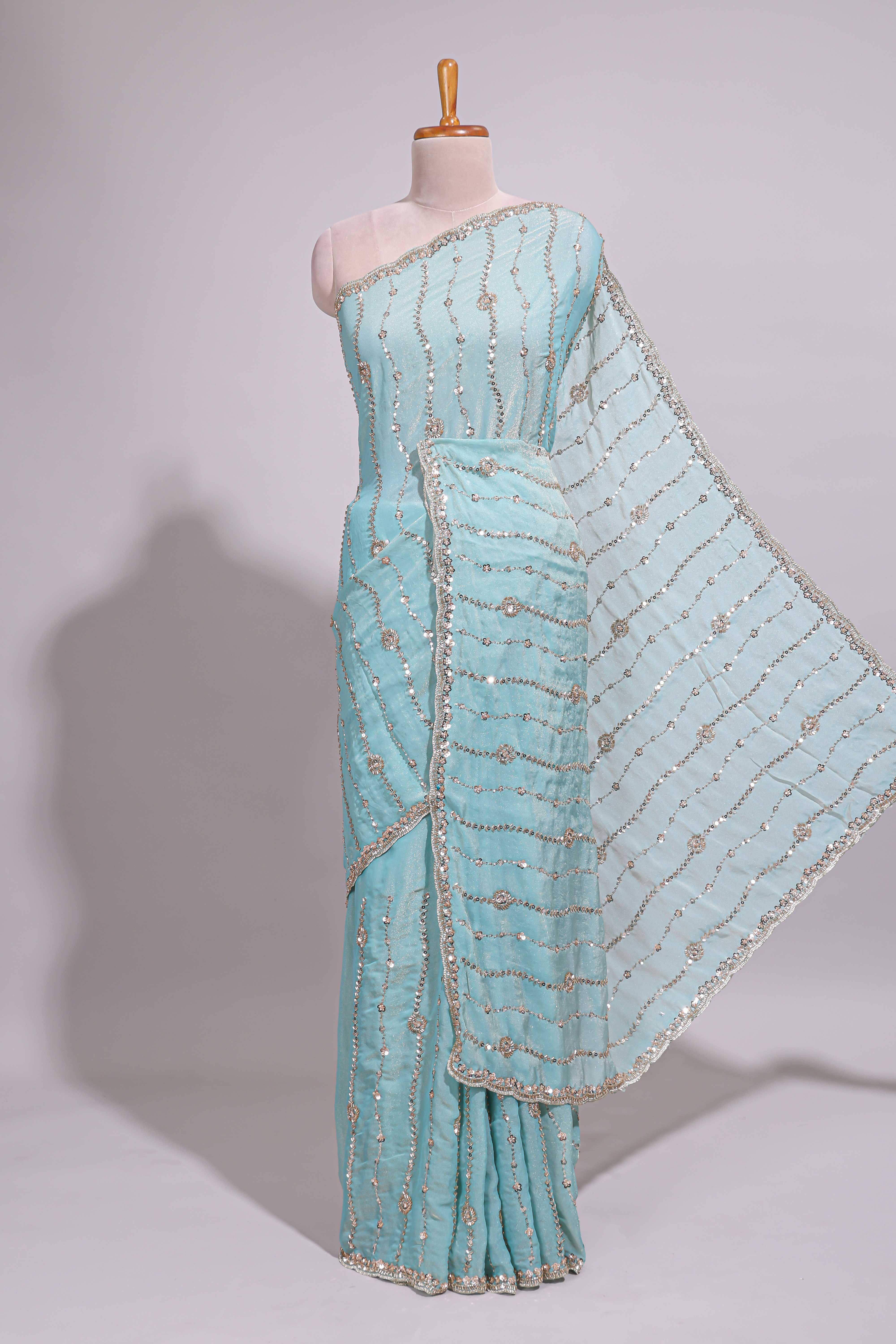 Pastel blue saree with silver sequin wavy line embroidery floral motifs and a sparkling embellished border along with matching blouse