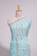 Pastel blue saree with silver sequin wavy line embroidery floral motifs and a sparkling embellished border along with matching blouse
