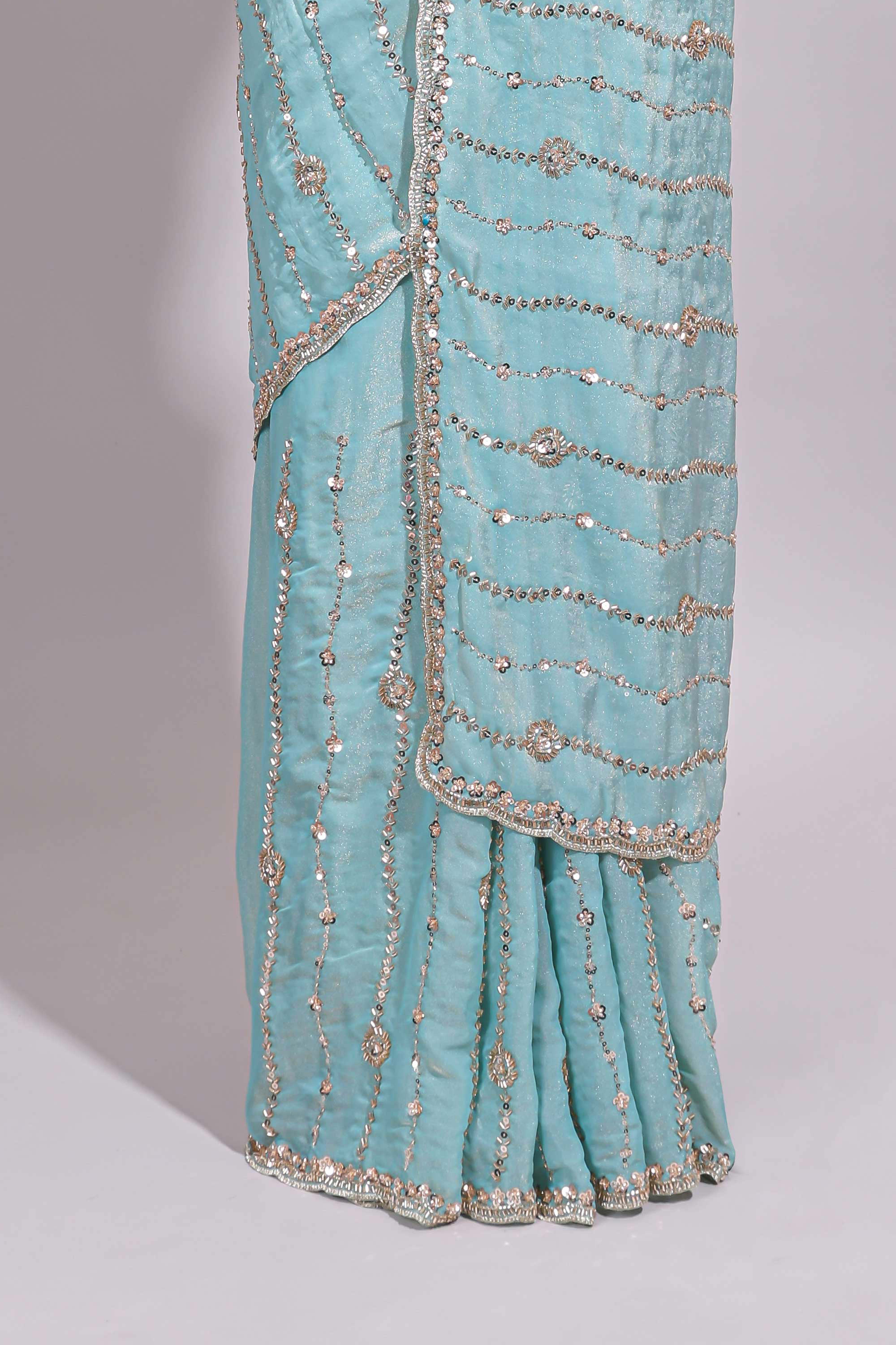 Pastel blue saree with silver sequin wavy line embroidery floral motifs and a sparkling embellished border along with matching blouse