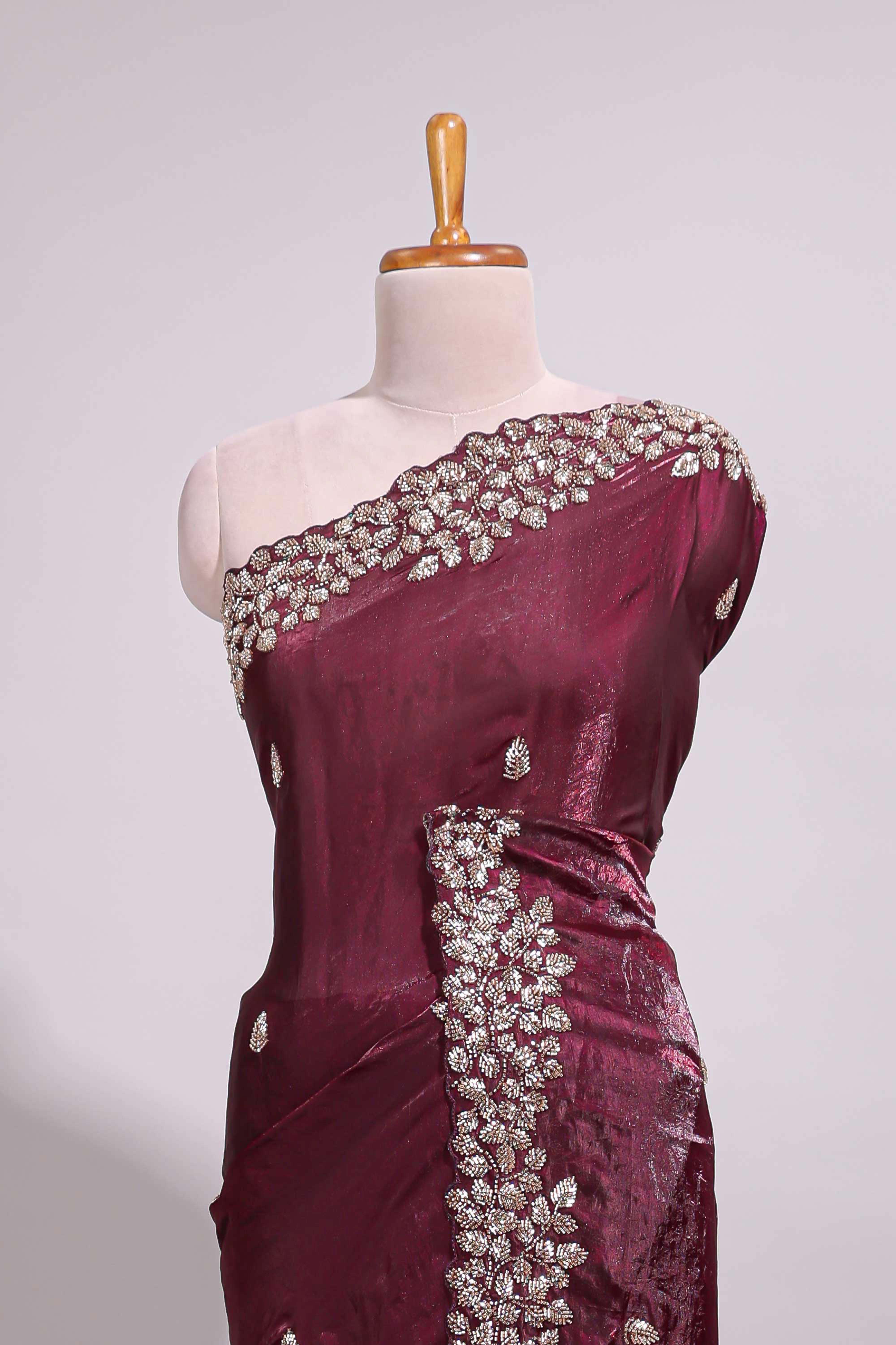 Deep wine saree with elegant golden floral embroidery and a rich embellished border along with matching blouse