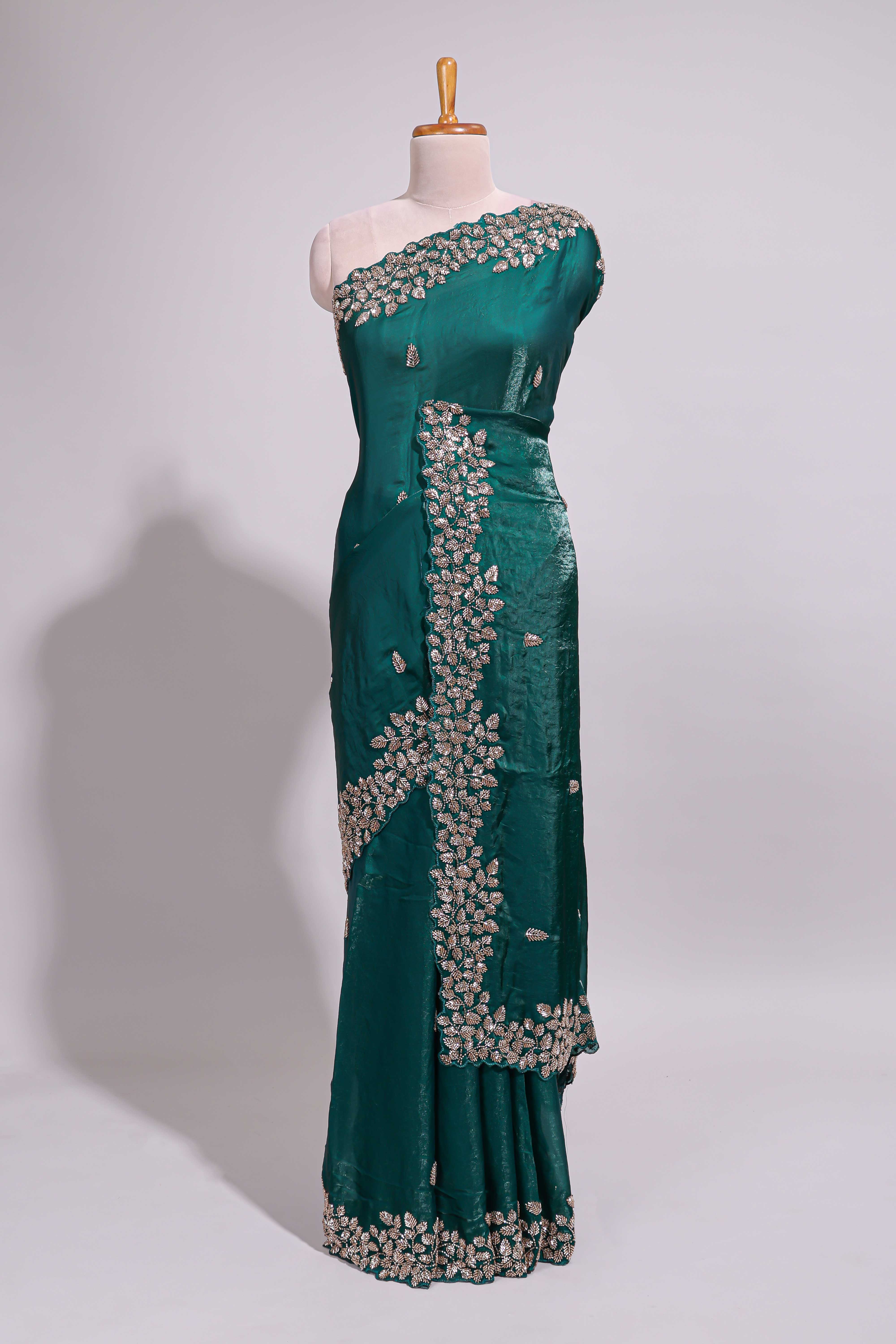 Bottle green saree with elegant golden floral embroidery and a rich embellished border along with matching blouse