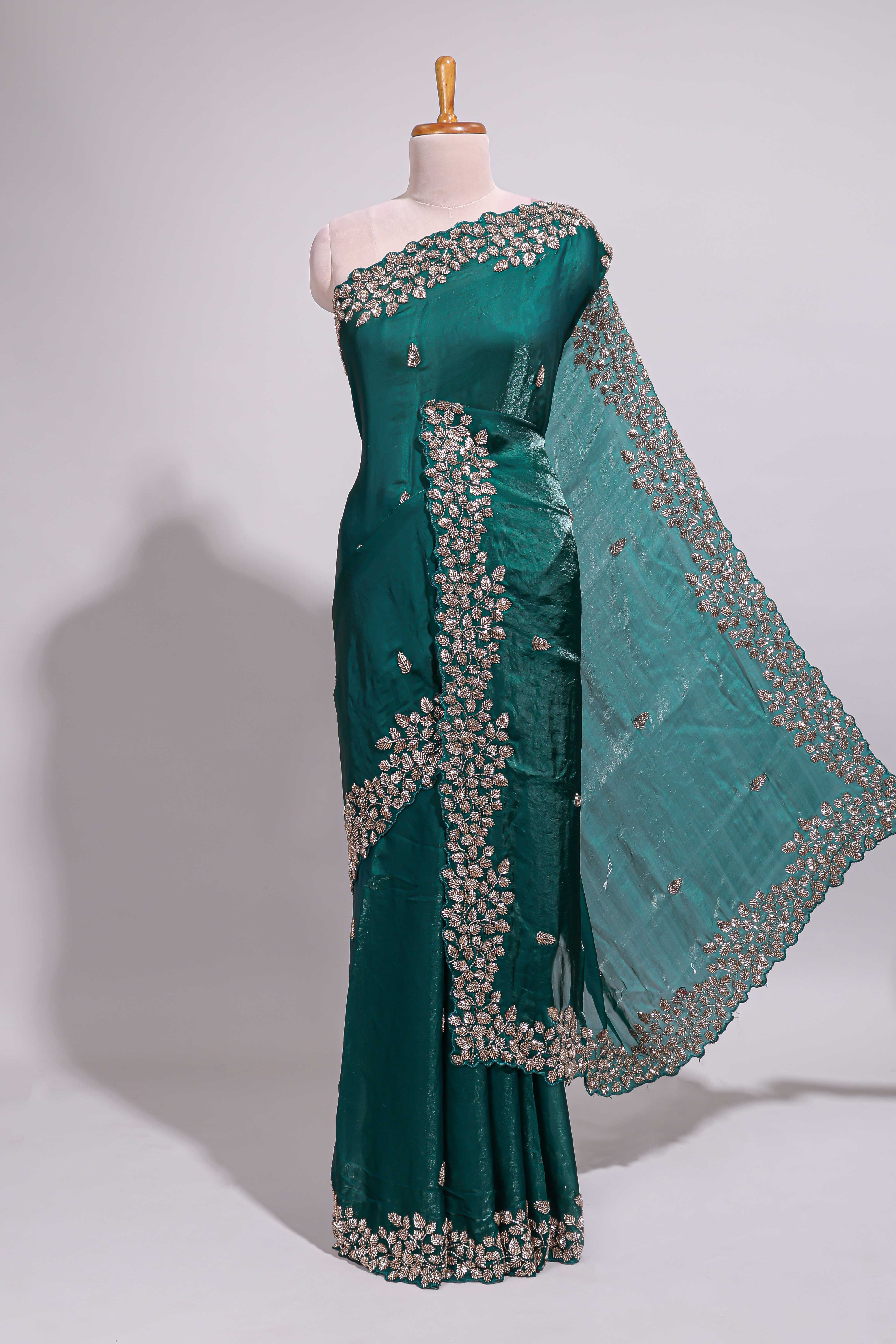 Bottle green saree with elegant golden floral embroidery and a rich embellished border along with matching blouse