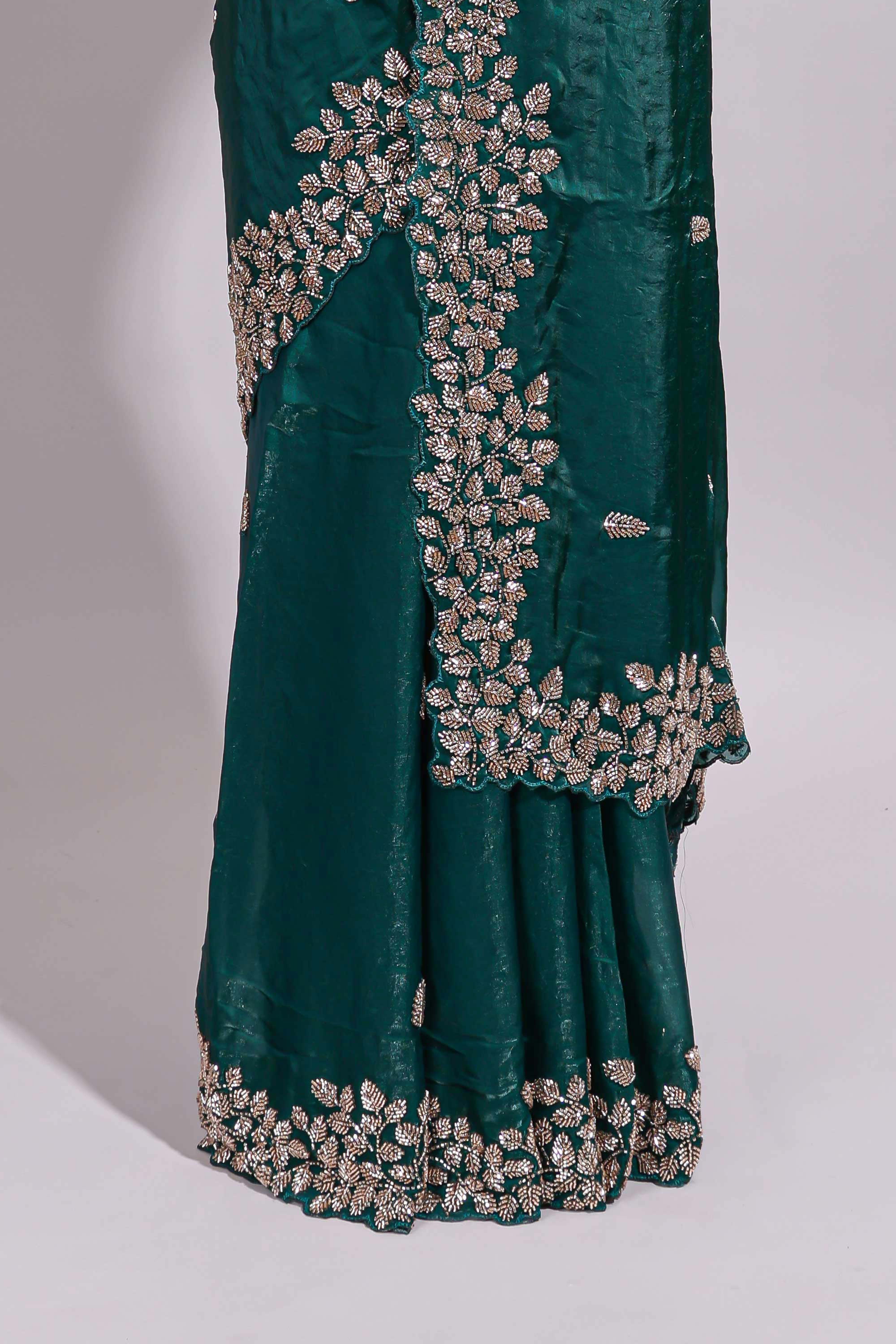 Bottle green saree with elegant golden floral embroidery and a rich embellished border along with matching blouse