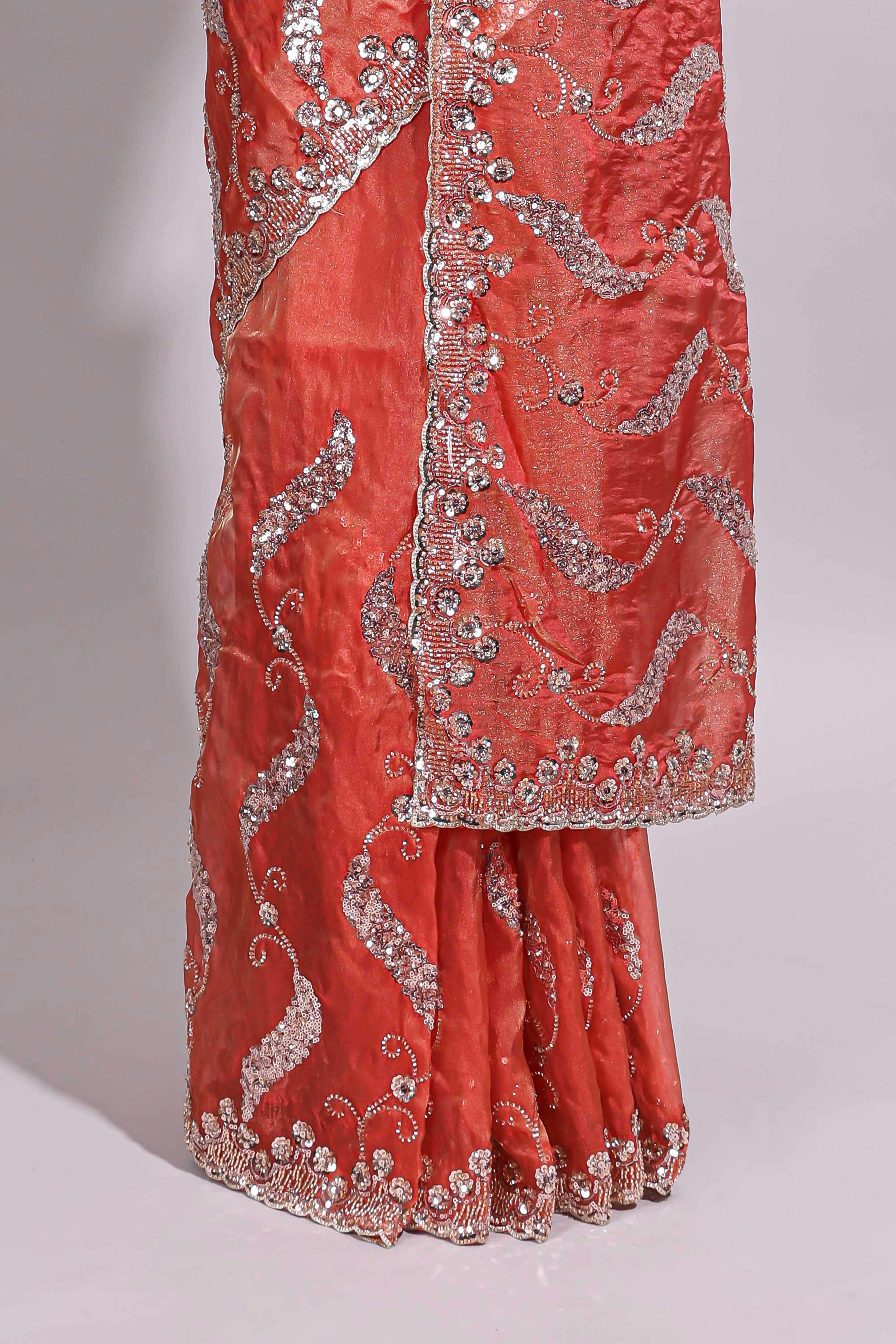 Dusty orange saree with sequin abstract wave embroidery and a detailed embellished border along with matching blouse