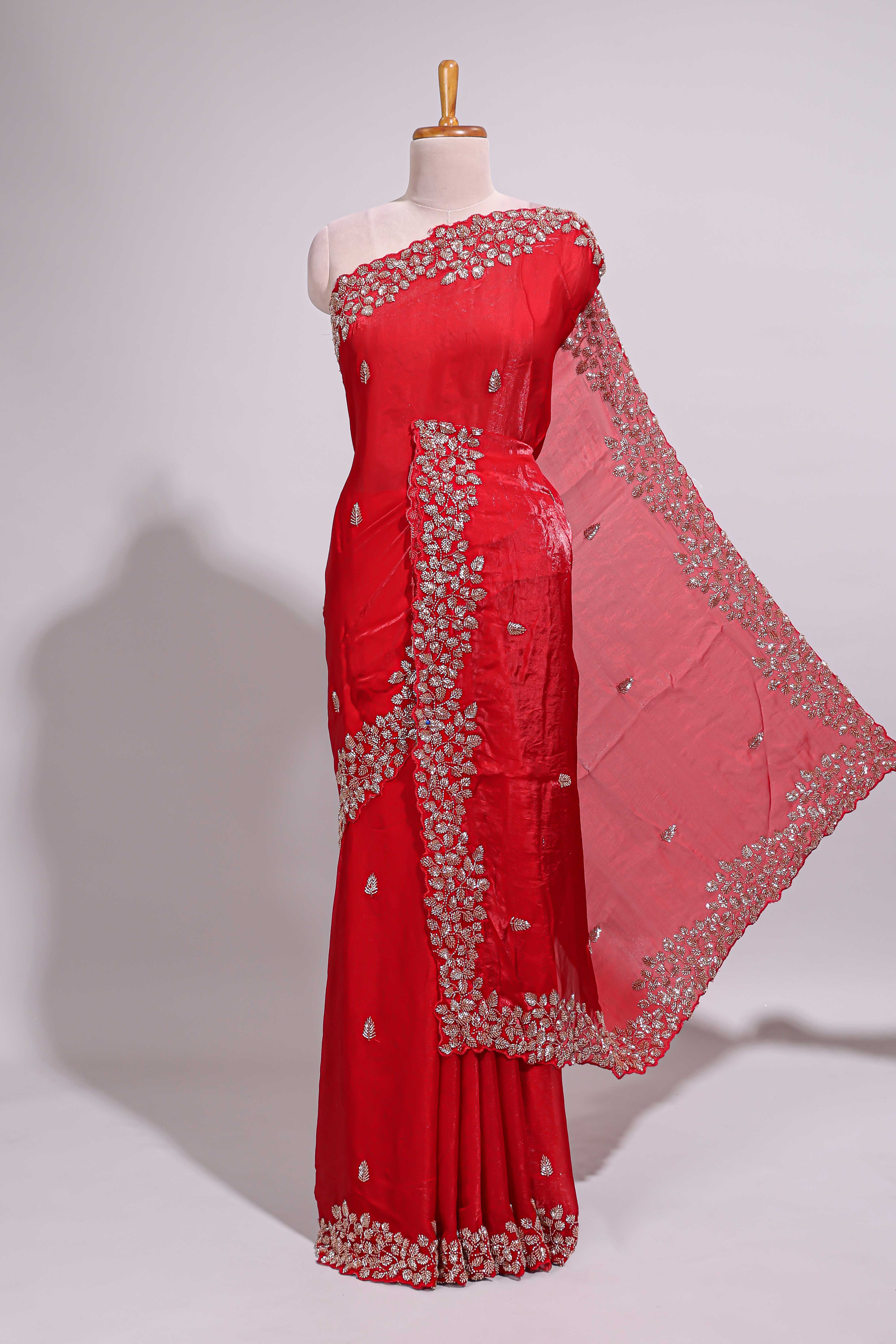 Bright red saree with elegant golden floral embroidery and a rich embellished border along with matching blouse