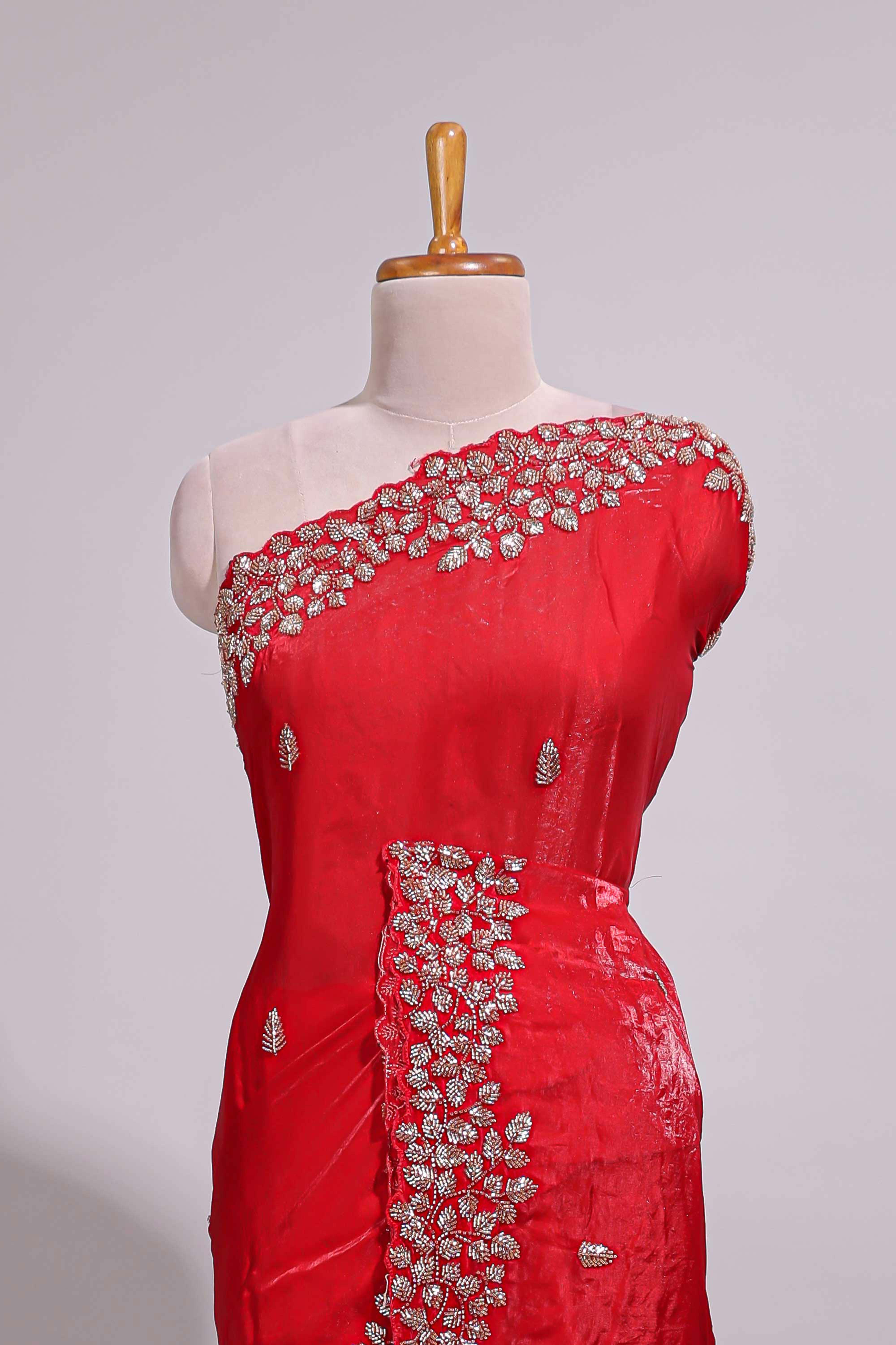 Bright red saree with elegant golden floral embroidery and a rich embellished border along with matching blouse