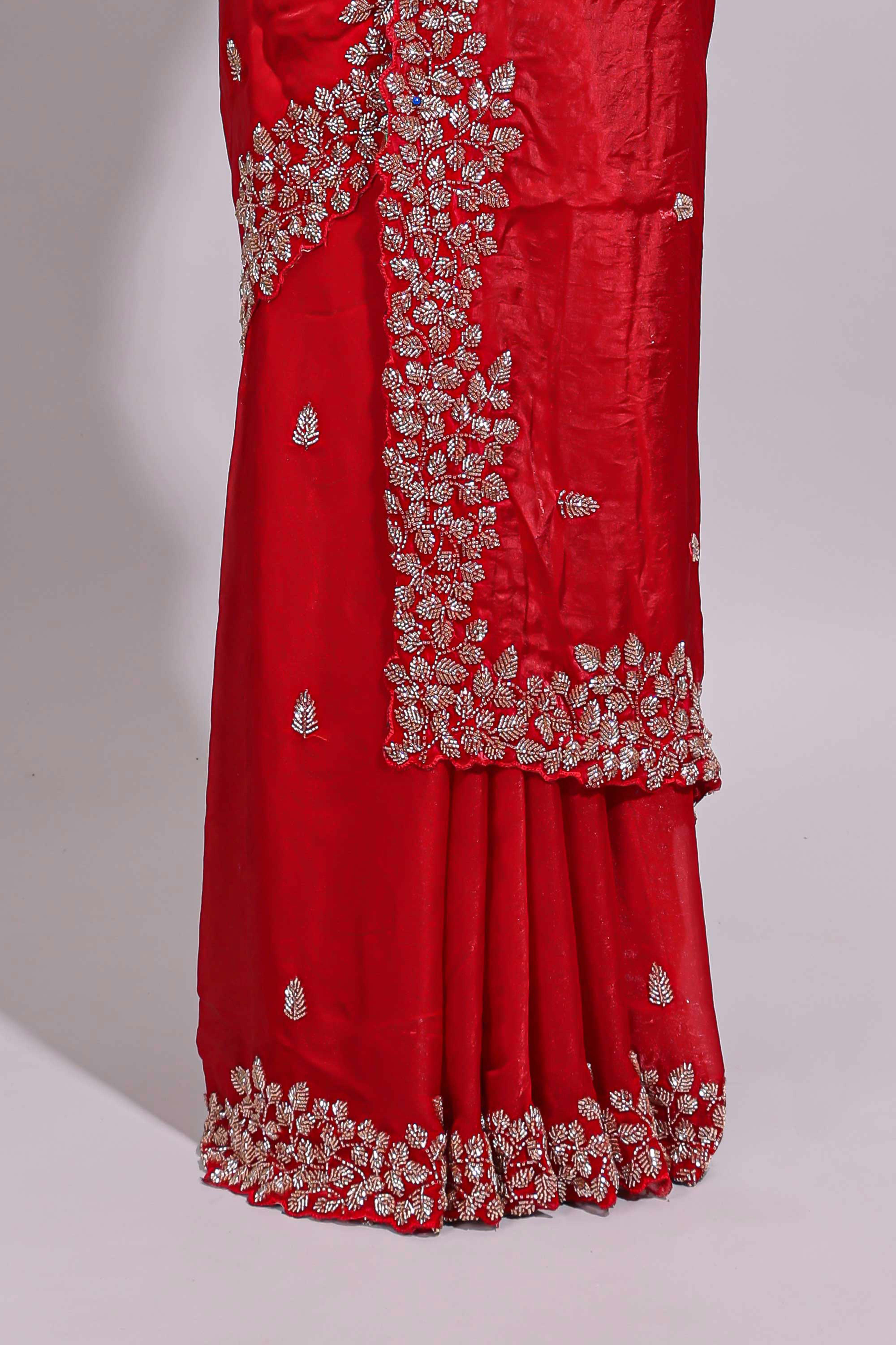 Bright red saree with elegant golden floral embroidery and a rich embellished border along with matching blouse