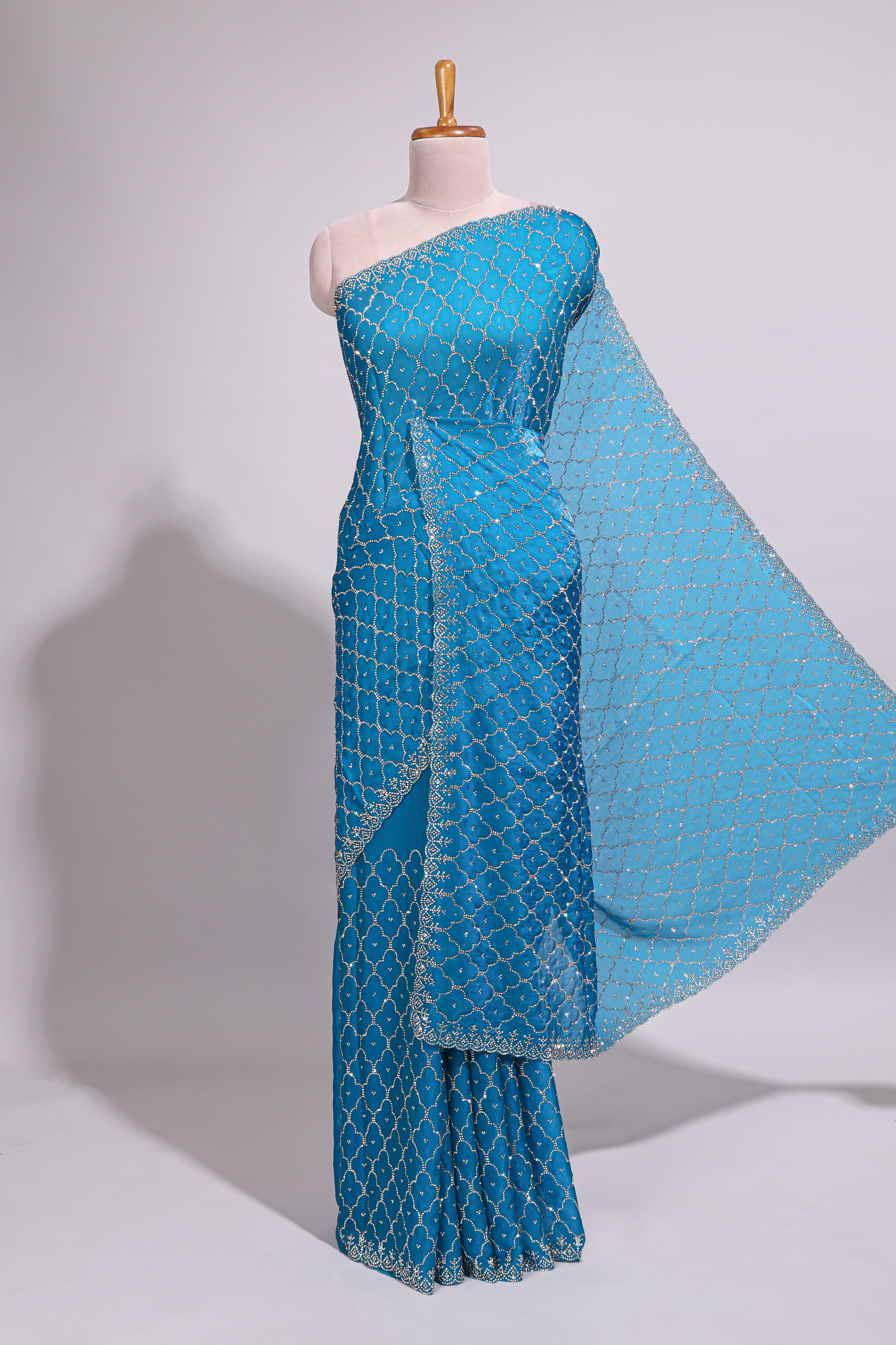 Blue saree with all over scallop pattern embroidery sequin detailing and a delicate embellished border along with matching blouse