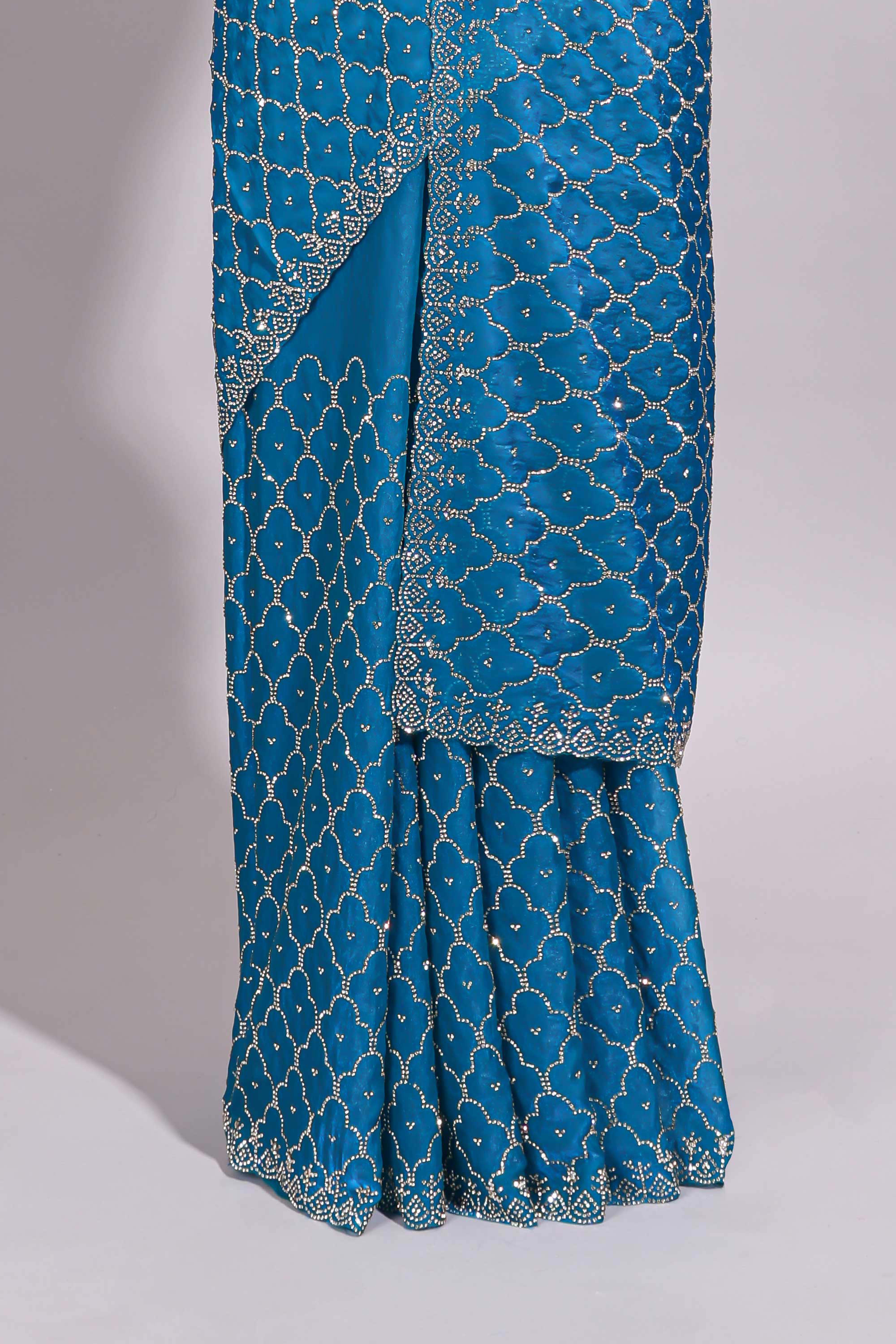 Blue saree with all over scallop pattern embroidery sequin detailing and a delicate embellished border along with matching blouse