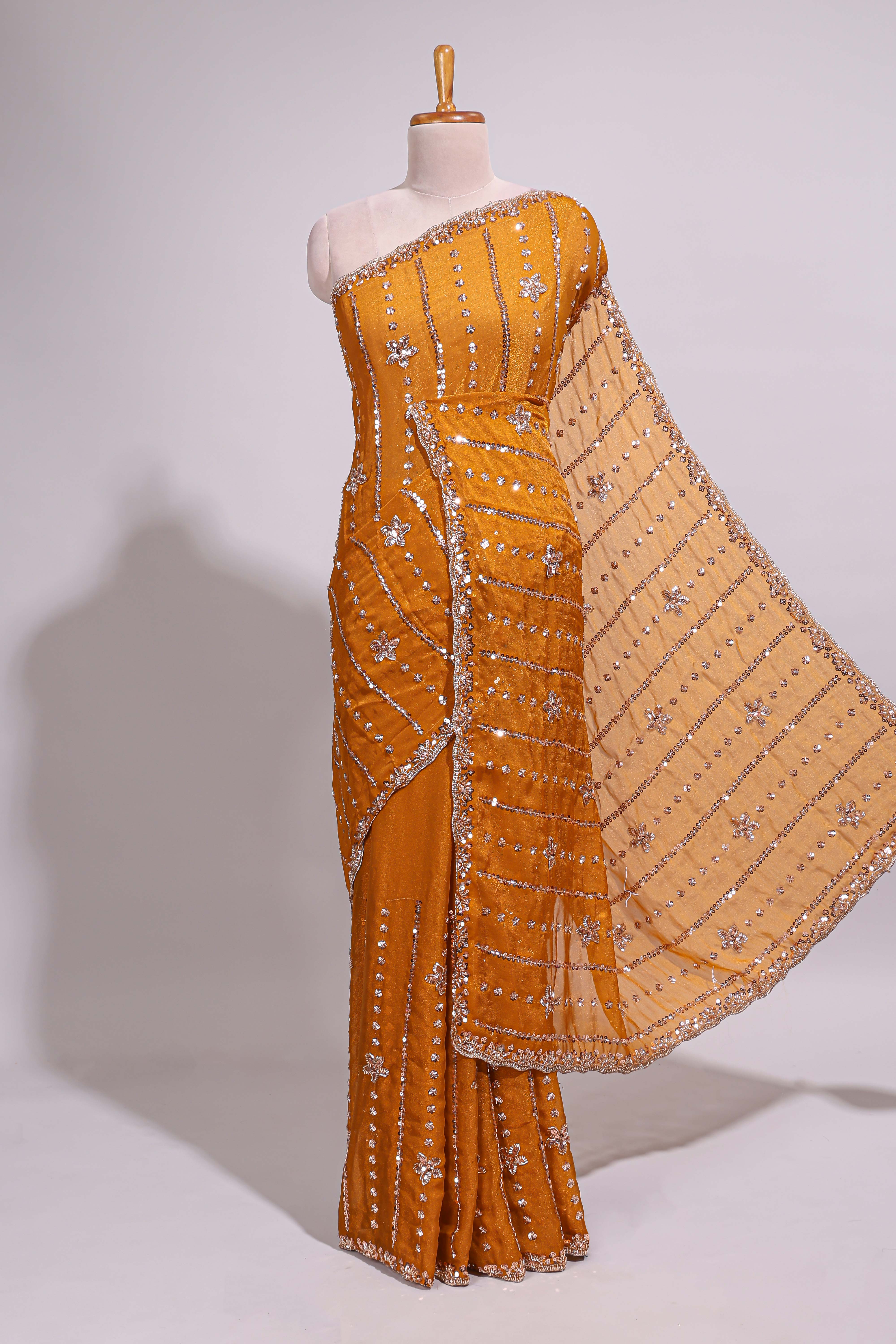 Mustard yellow saree with silver sequin vertical lines floral motifs embellished border and matching pallu design along with matching blouse