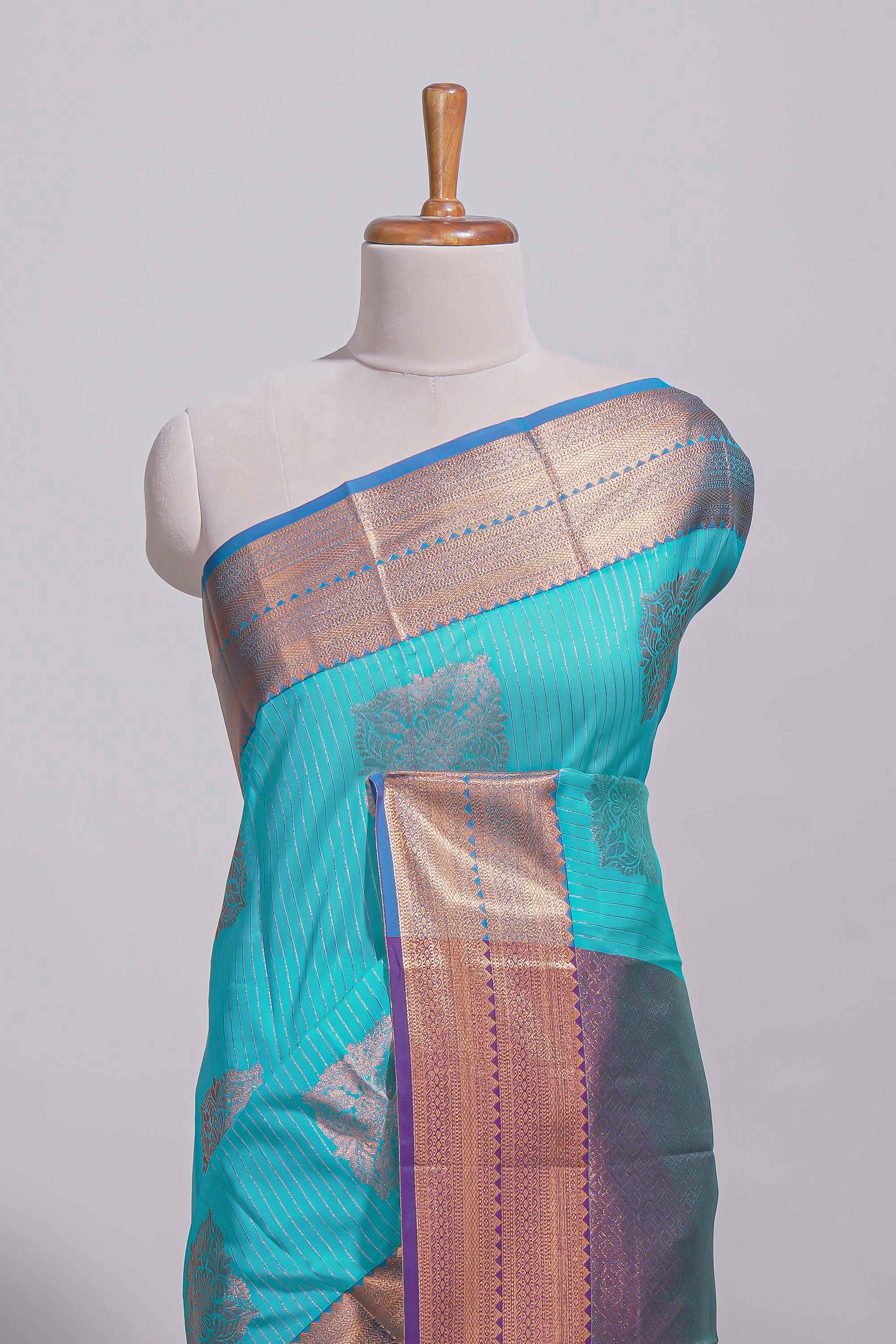 Blue tussar saree with gold zari floral buttas teal zari border and woven zari pallu with contrast blouse piece