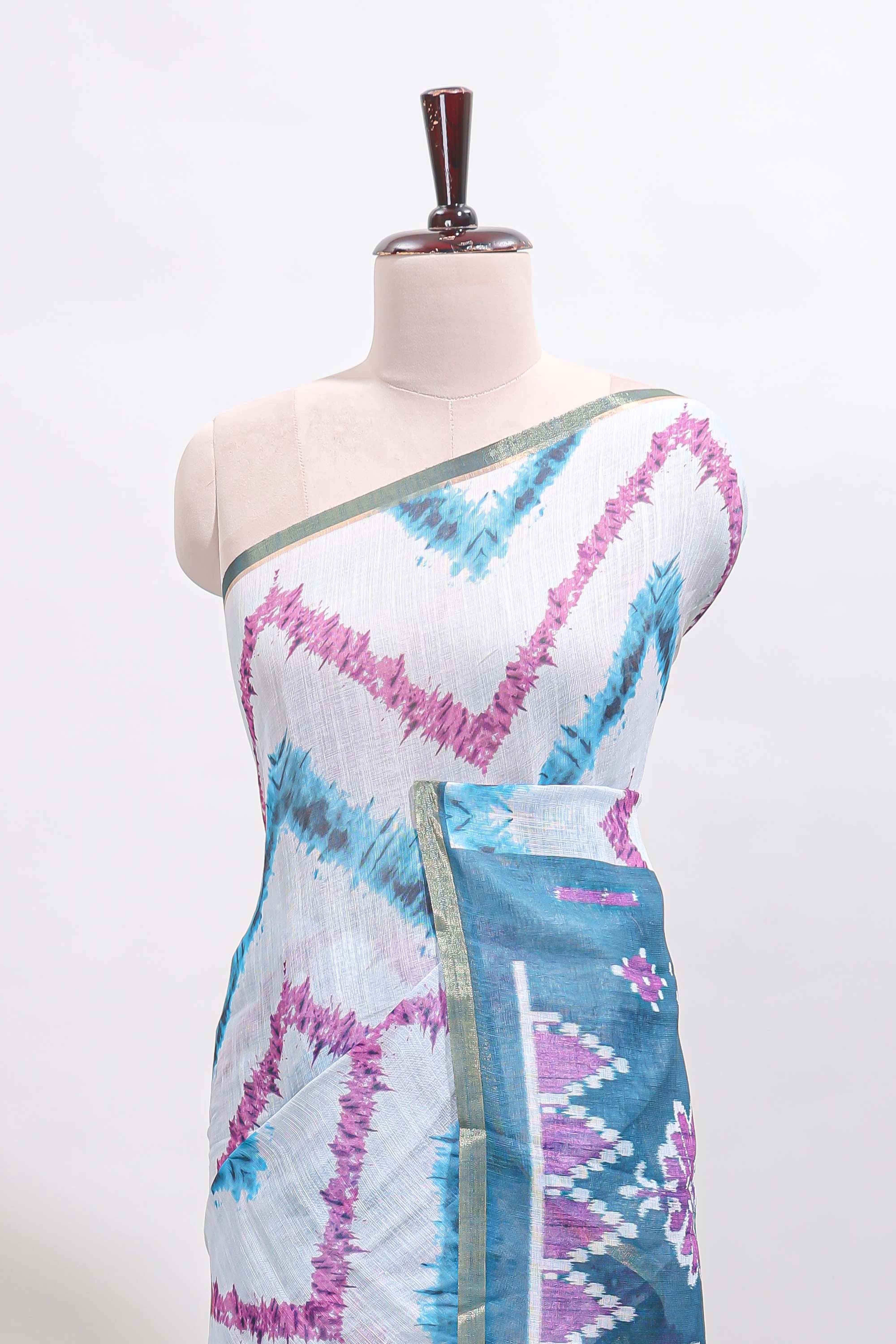 Off white chevron style shibori print linen cotton saree with contrast turquoise blue border and ikkat design pallu