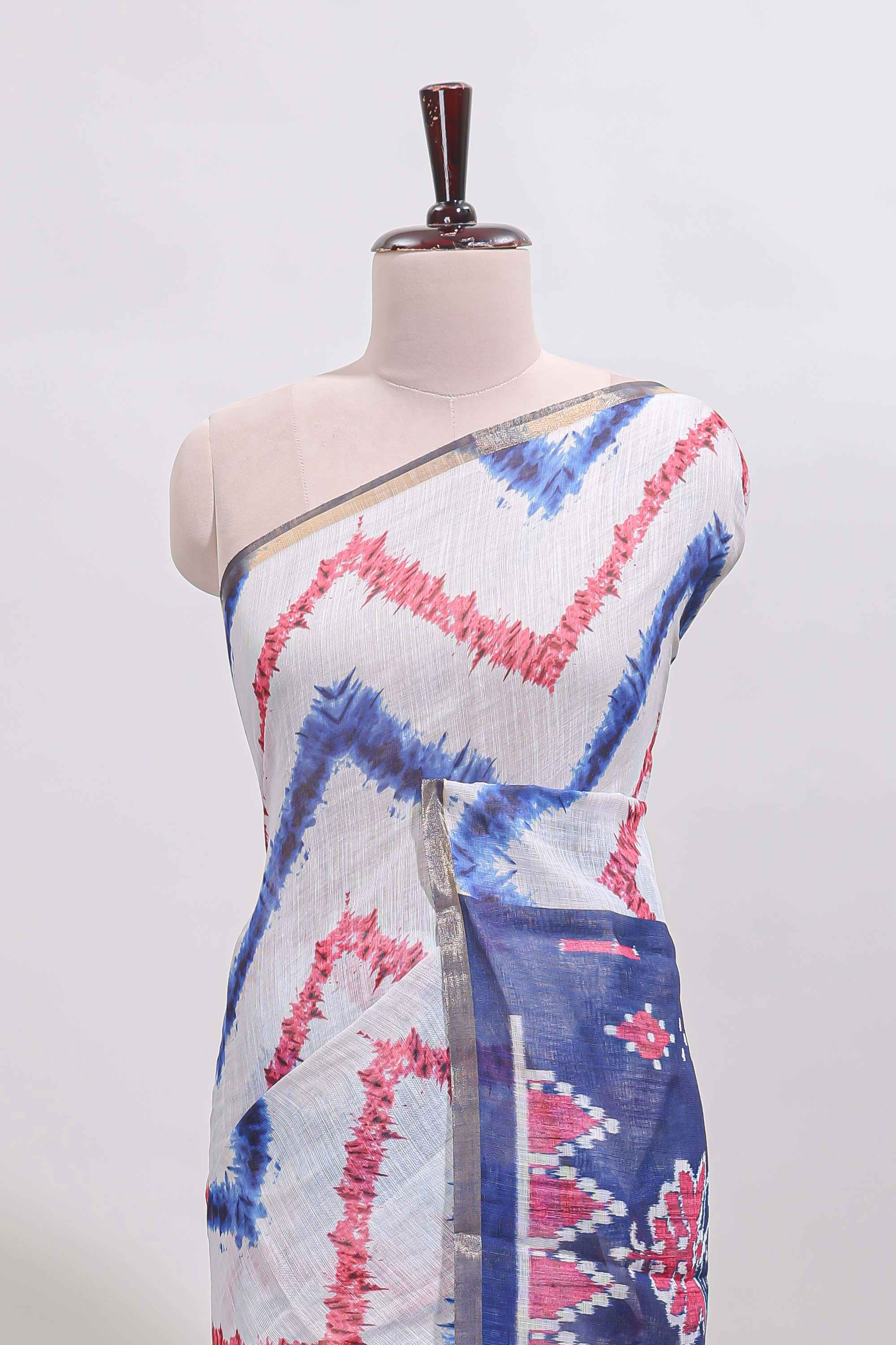 Off white chevron style shibori print linen cotton saree with contrast blue border and ikkat design pallu