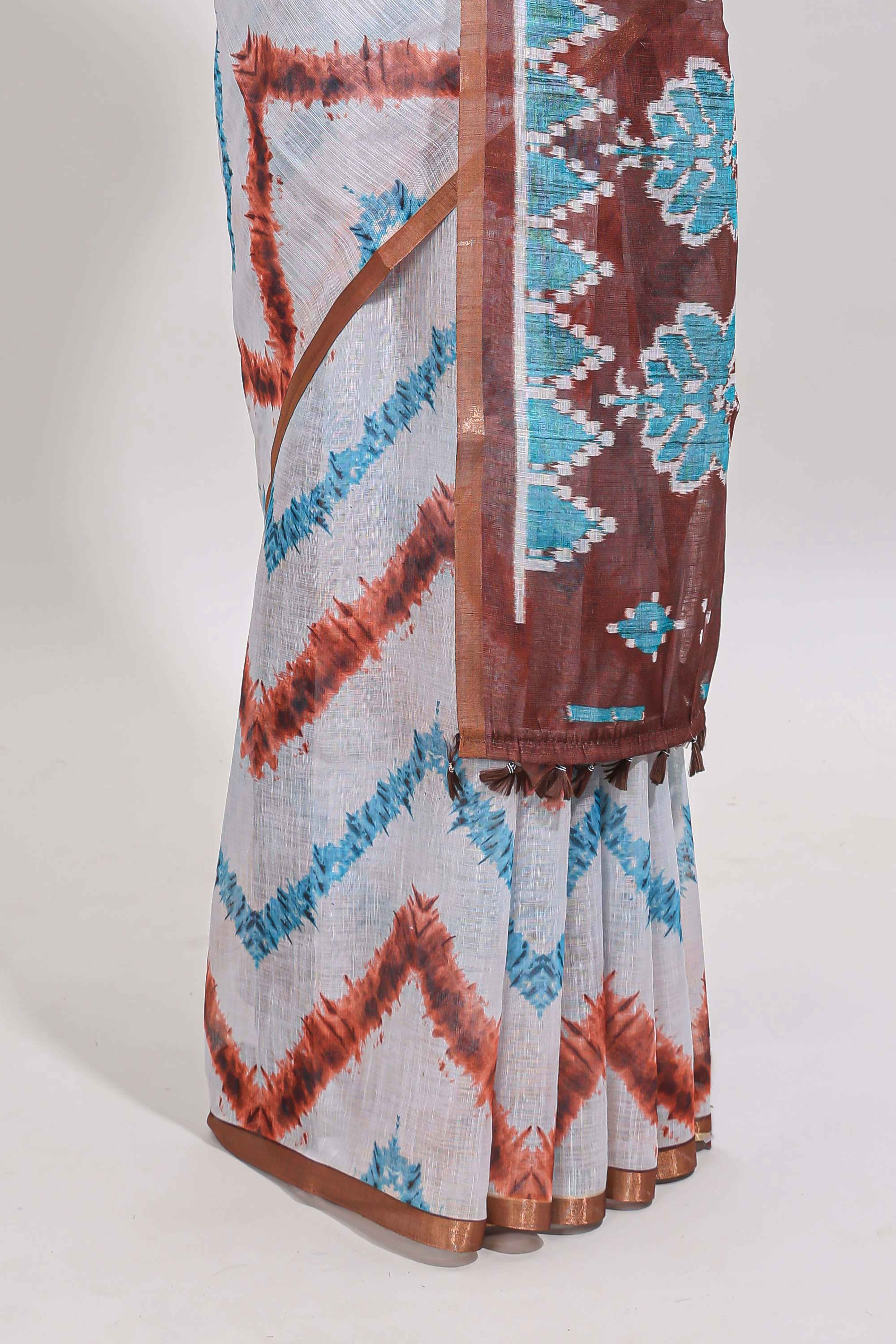 Off white chevron style shibori print linen cotton saree with contrast brown border and ikkat design pallu