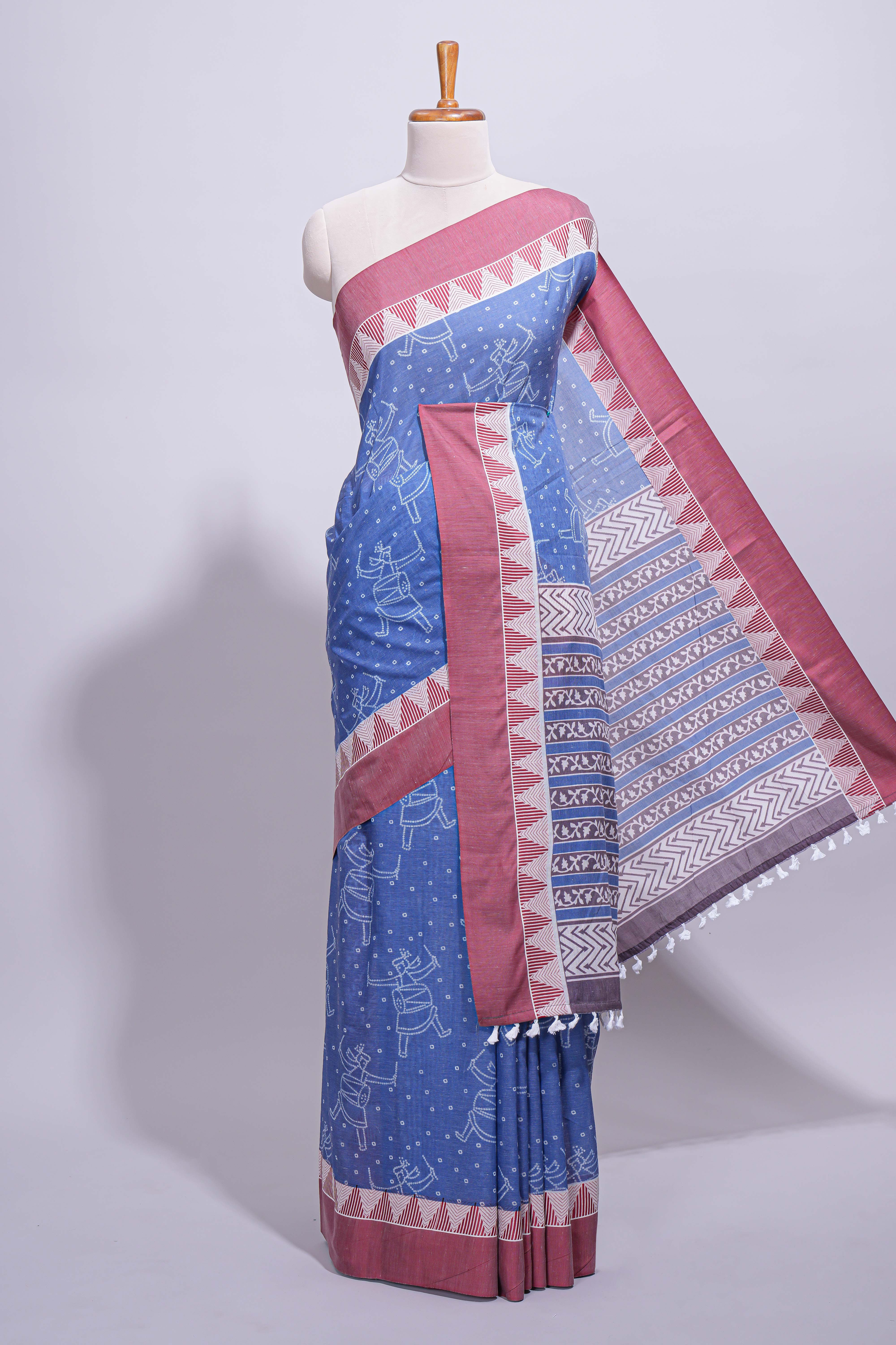 Blue linen small dotted elephant and floral motifs contrast border and printed pallu with geometric patterns and tassel detailing along with printed blouse