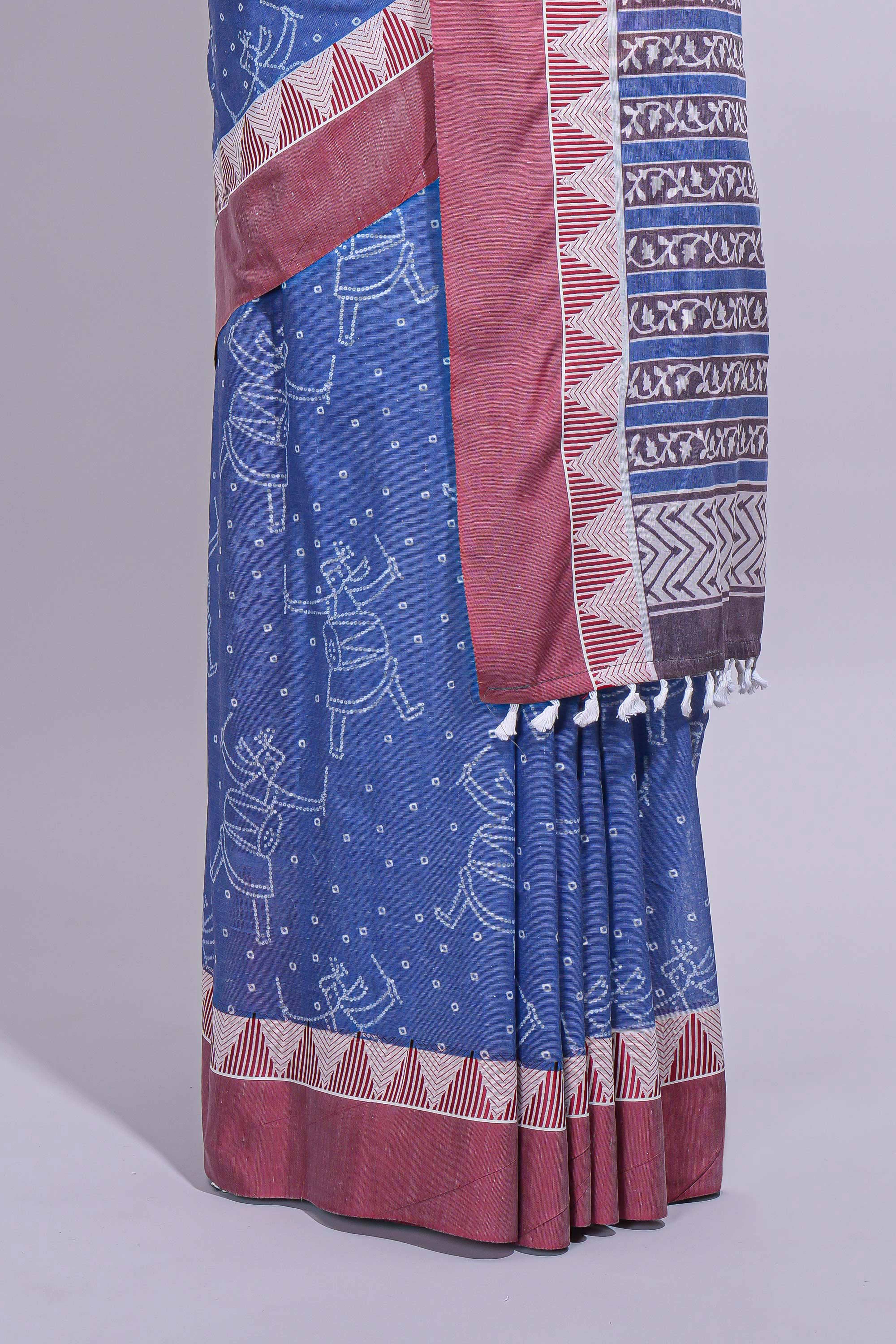 Blue linen small dotted elephant and floral motifs contrast border and printed pallu with geometric patterns and tassel detailing along with printed blouse