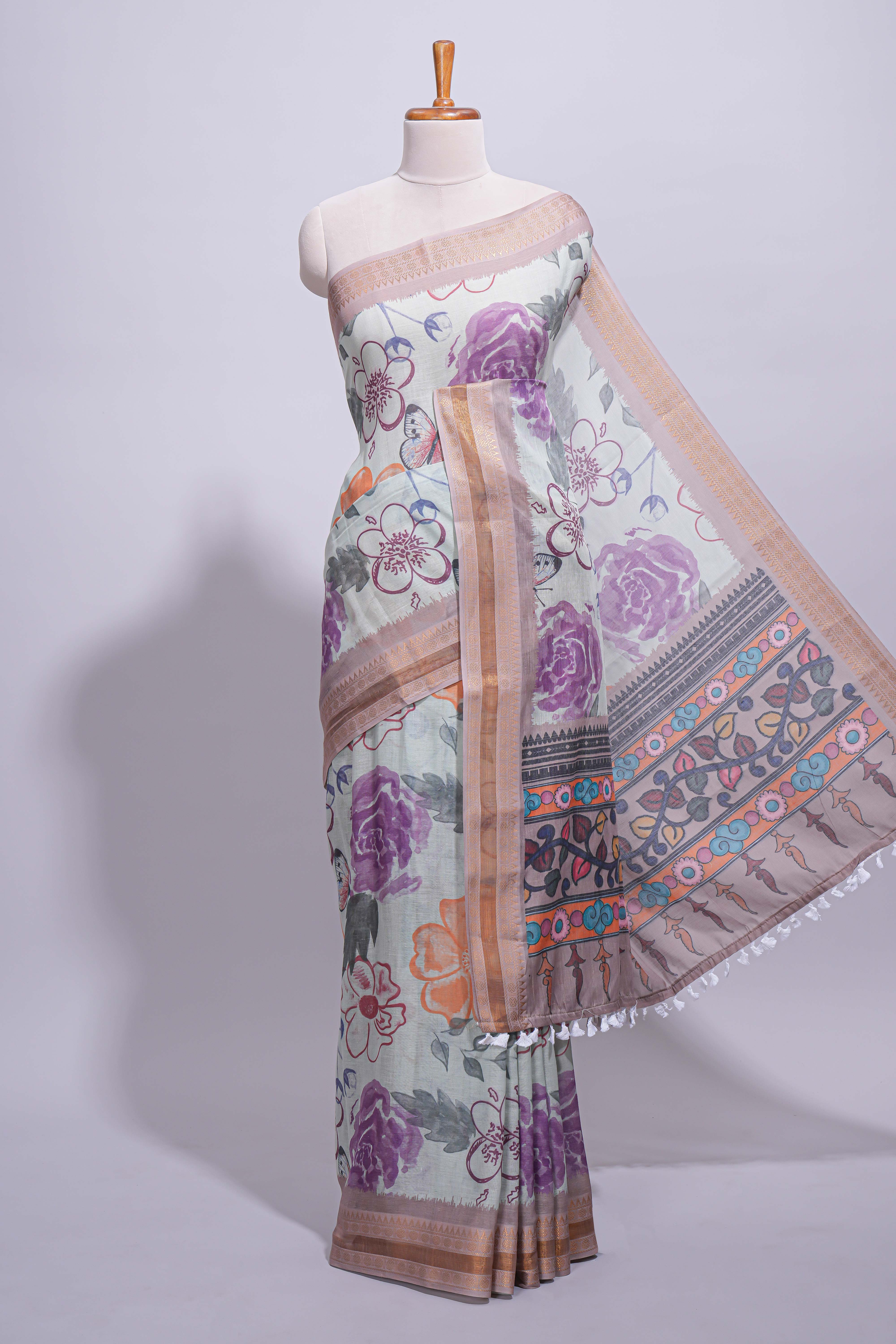 Ivory colour linen saree floral prints with pastel accents by a subtle gold zari border and printed pallu with tassel along with printed blouse