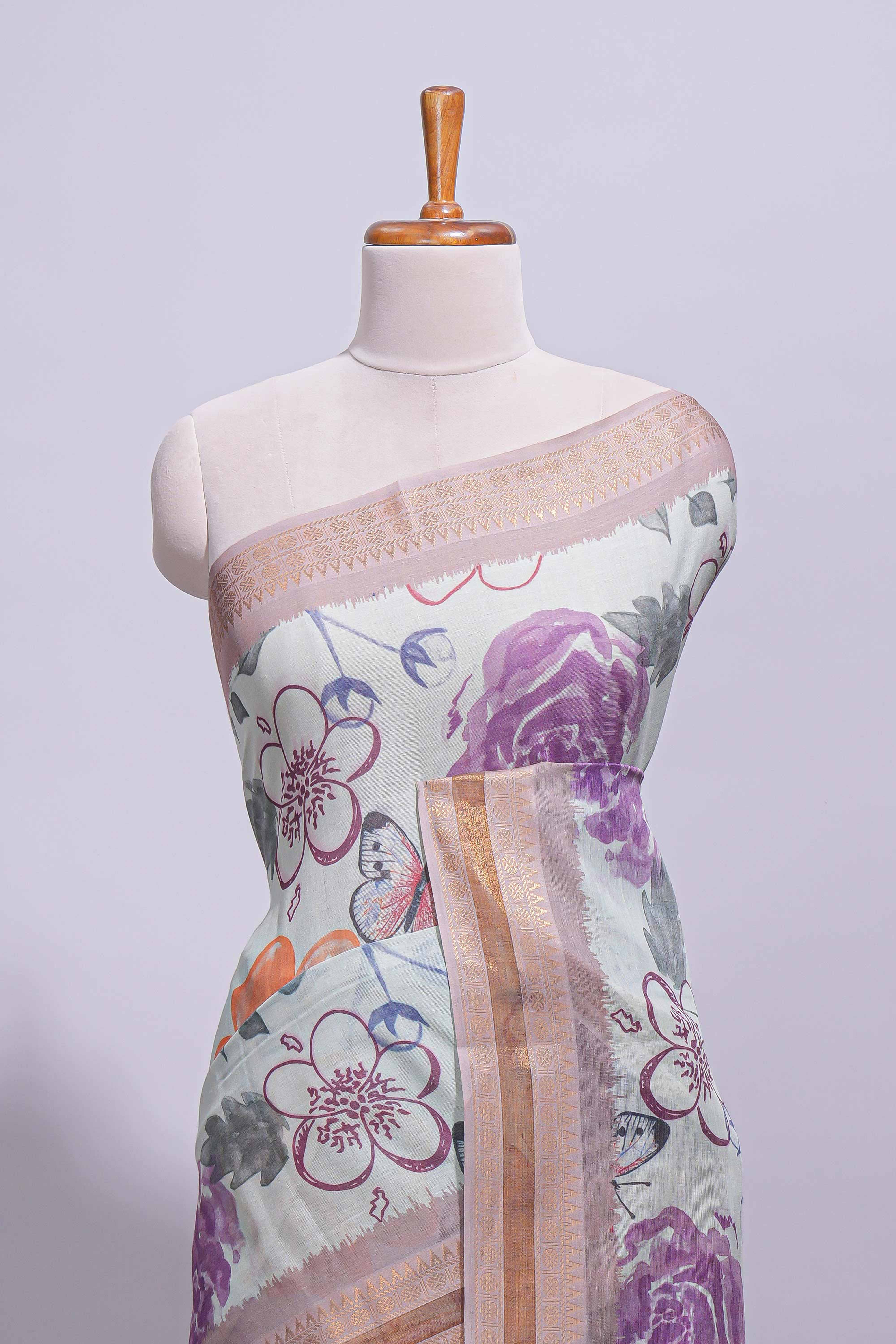 Ivory colour linen saree floral prints with pastel accents by a subtle gold zari border and printed pallu with tassel along with printed blouse