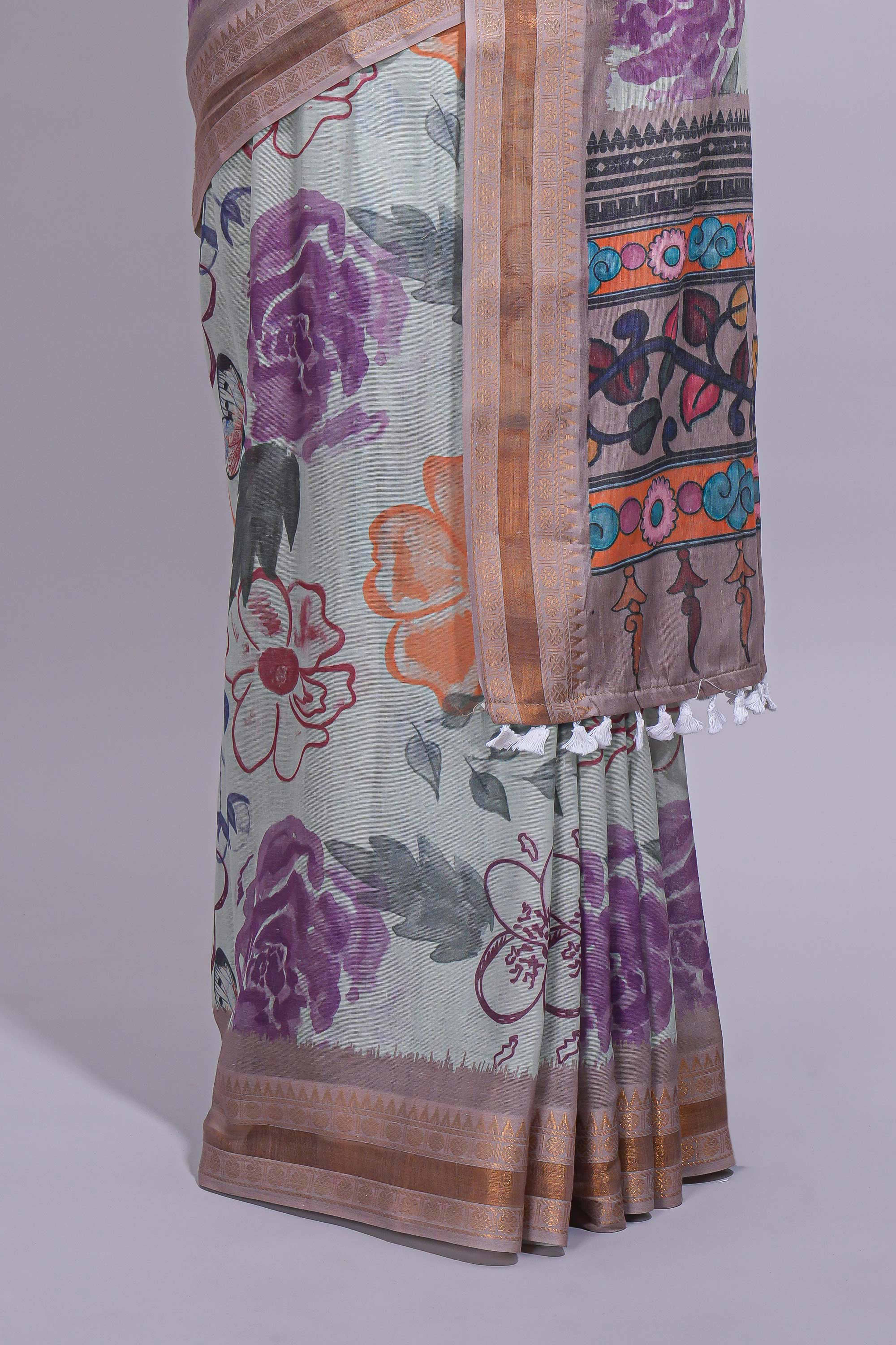 Ivory colour linen saree floral prints with pastel accents by a subtle gold zari border and printed pallu with tassel along with printed blouse