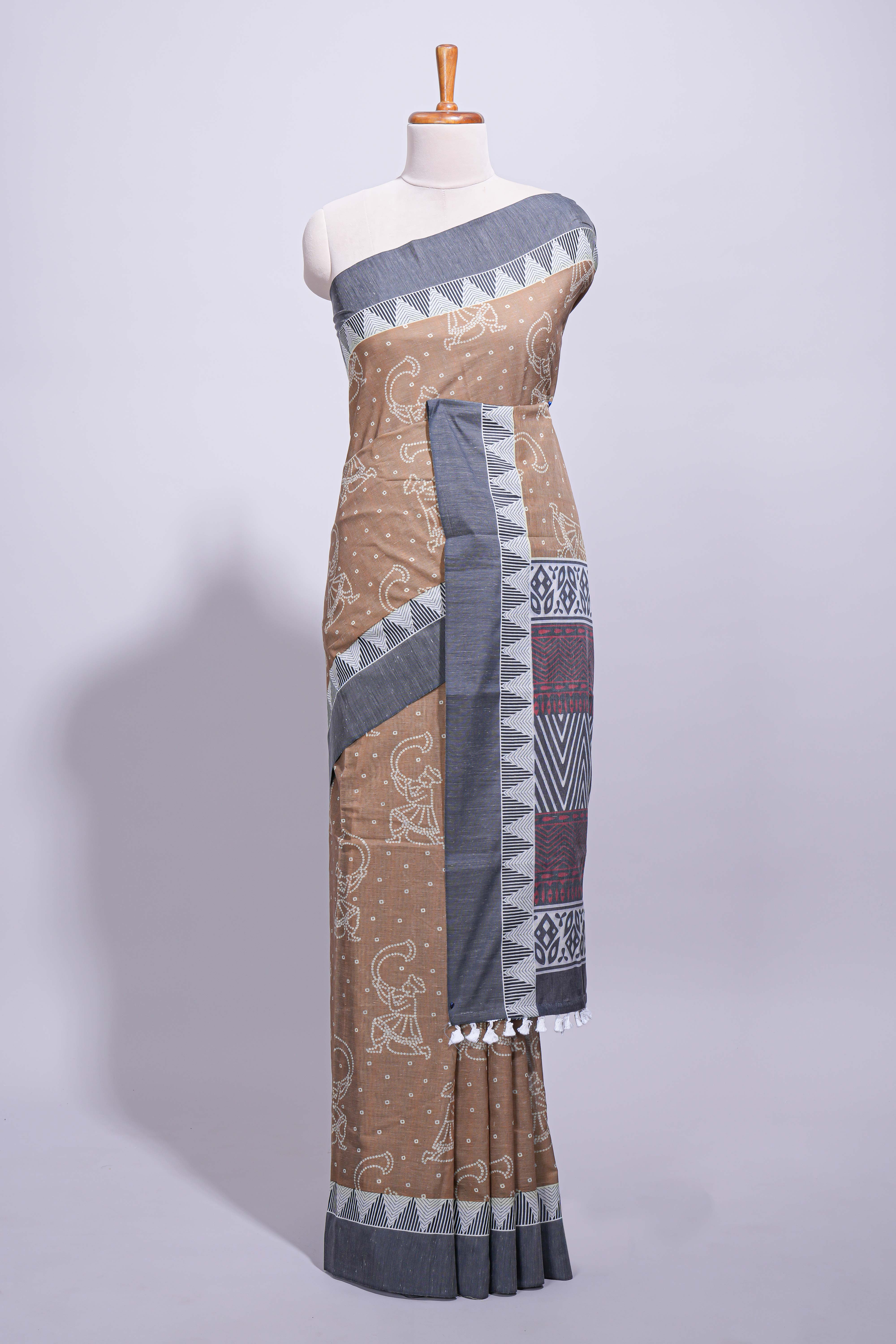 Brown linen small dotted elephant and floral motifs contrast border and printed pallu with geometric patterns and tassel detailing along with printed blouse