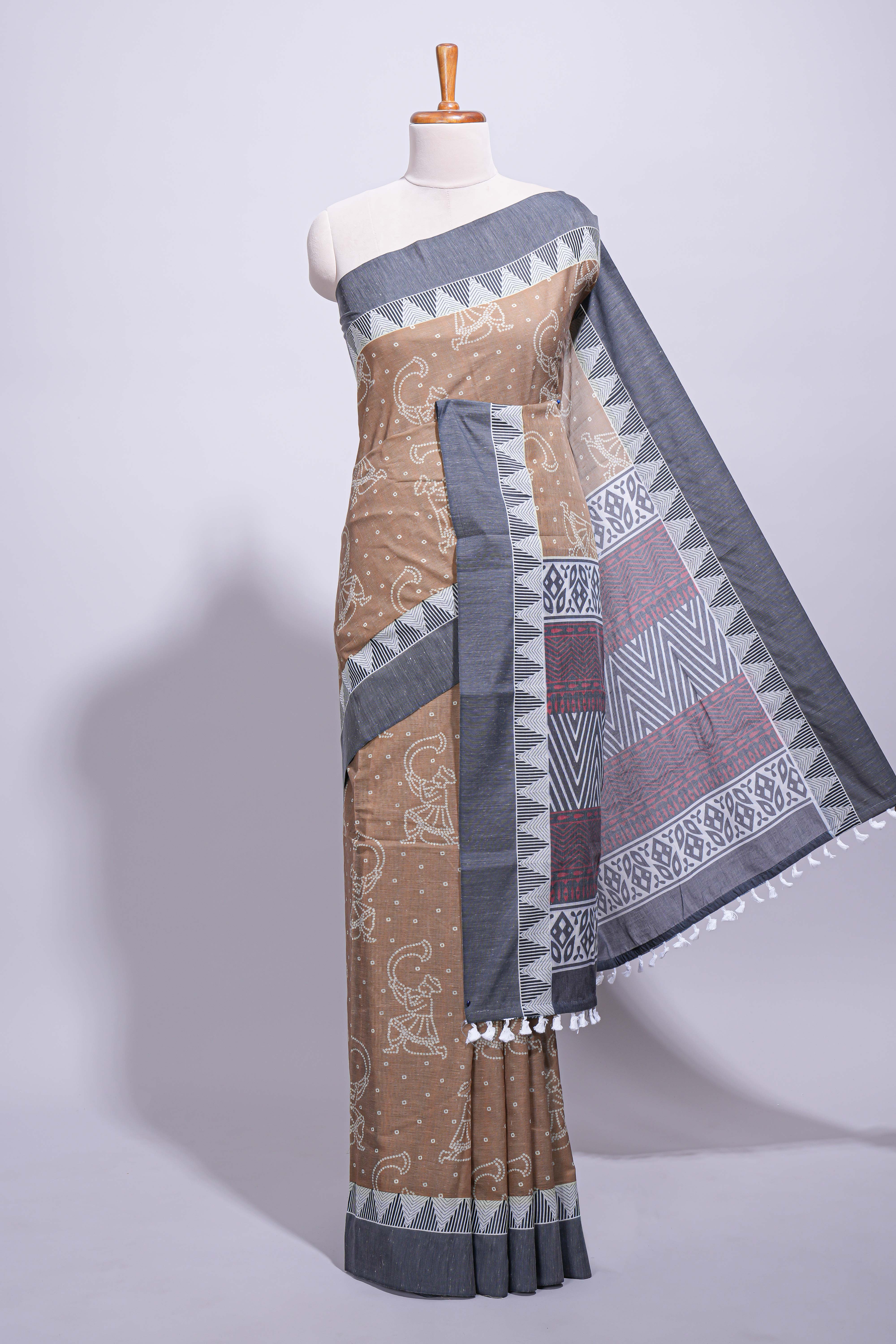 Brown linen small dotted elephant and floral motifs contrast border and printed pallu with geometric patterns and tassel detailing along with printed blouse