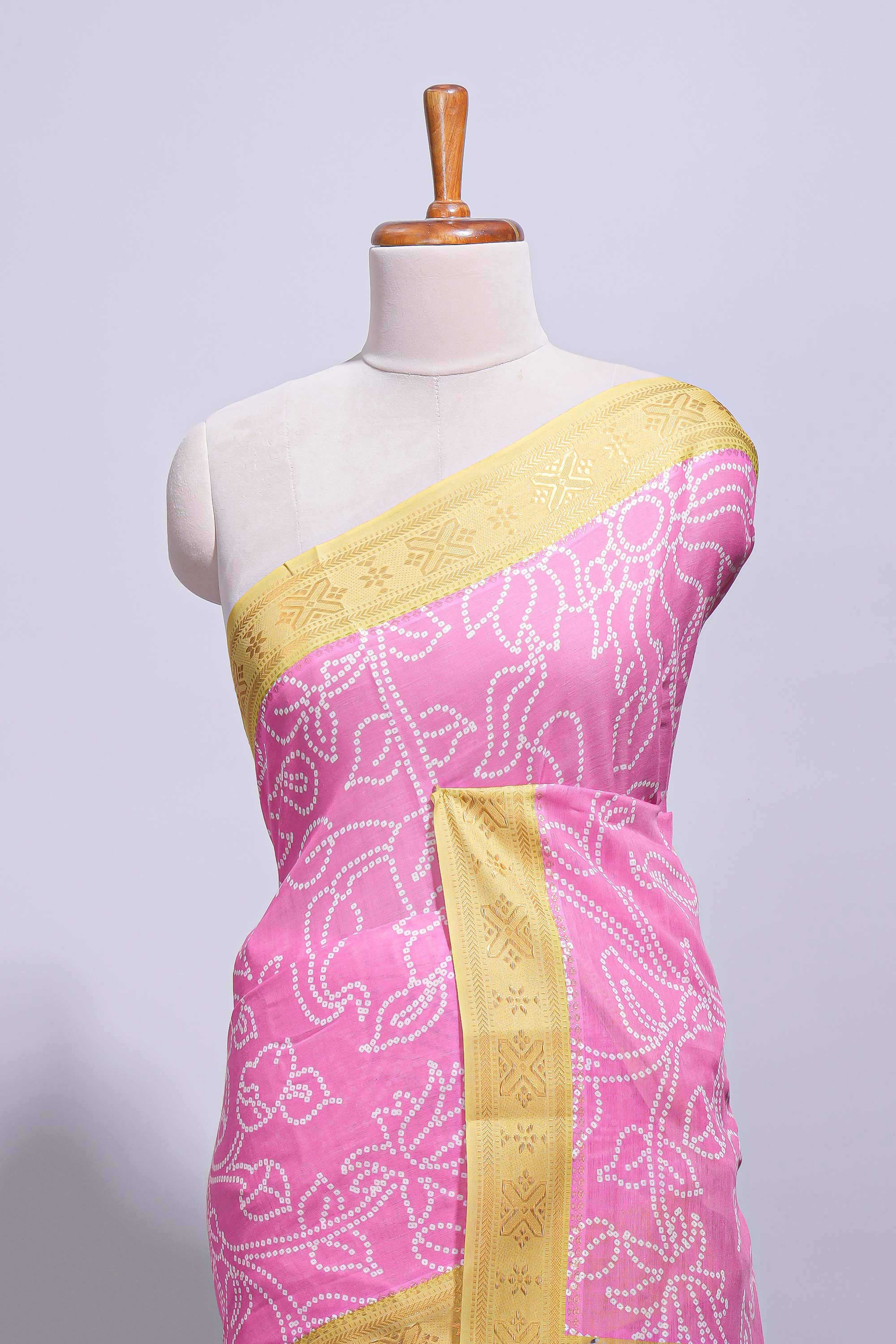 Pink linen saree with white dotted floral patterns with golden zari border and a multicolour pichwai motifs along with printed blouse