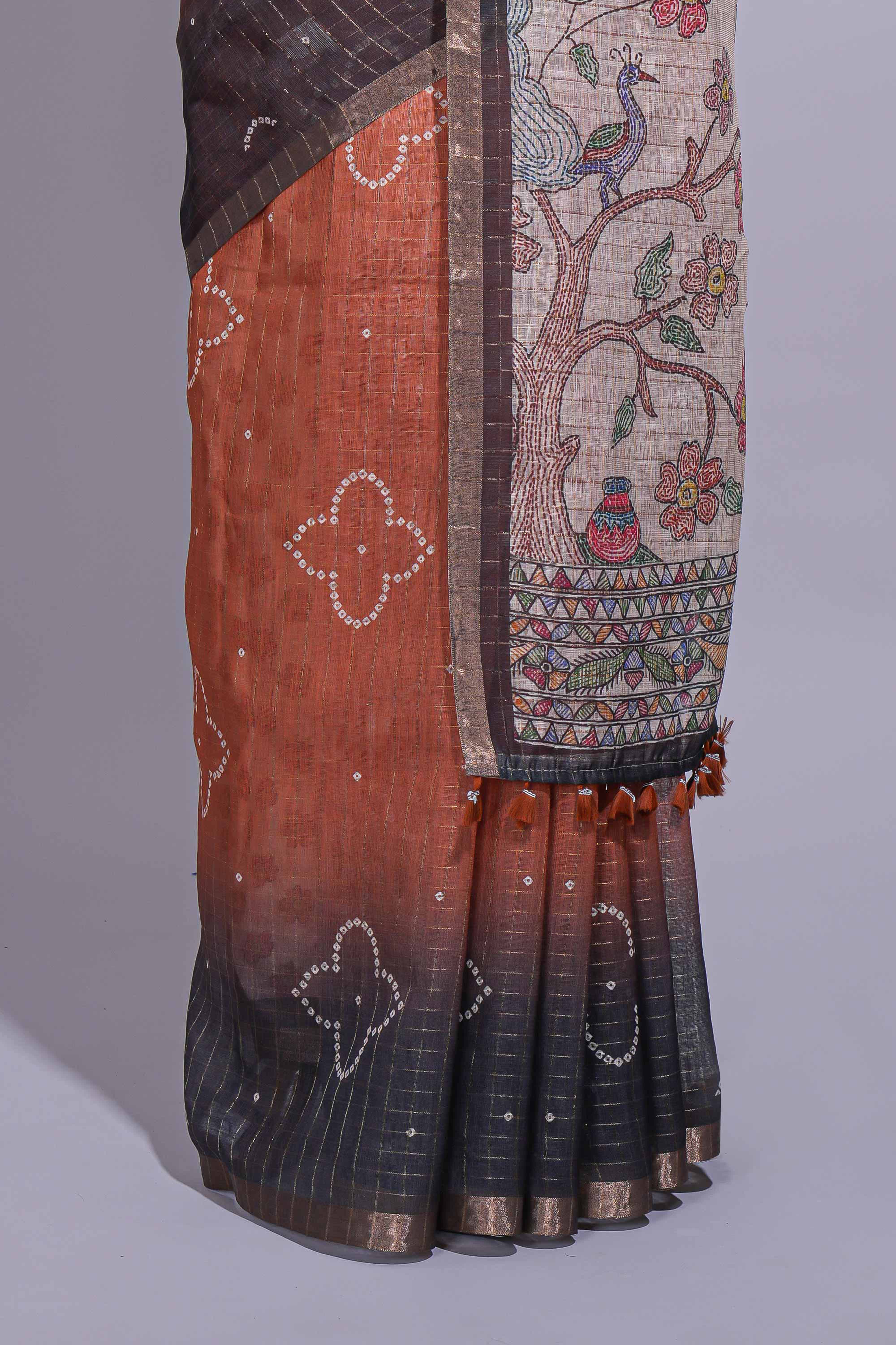 Elegant rust and charcoal linen saree with geometric dotted motifs paired with a floral printed pallu and contrast border with tassel along with printed blouse
