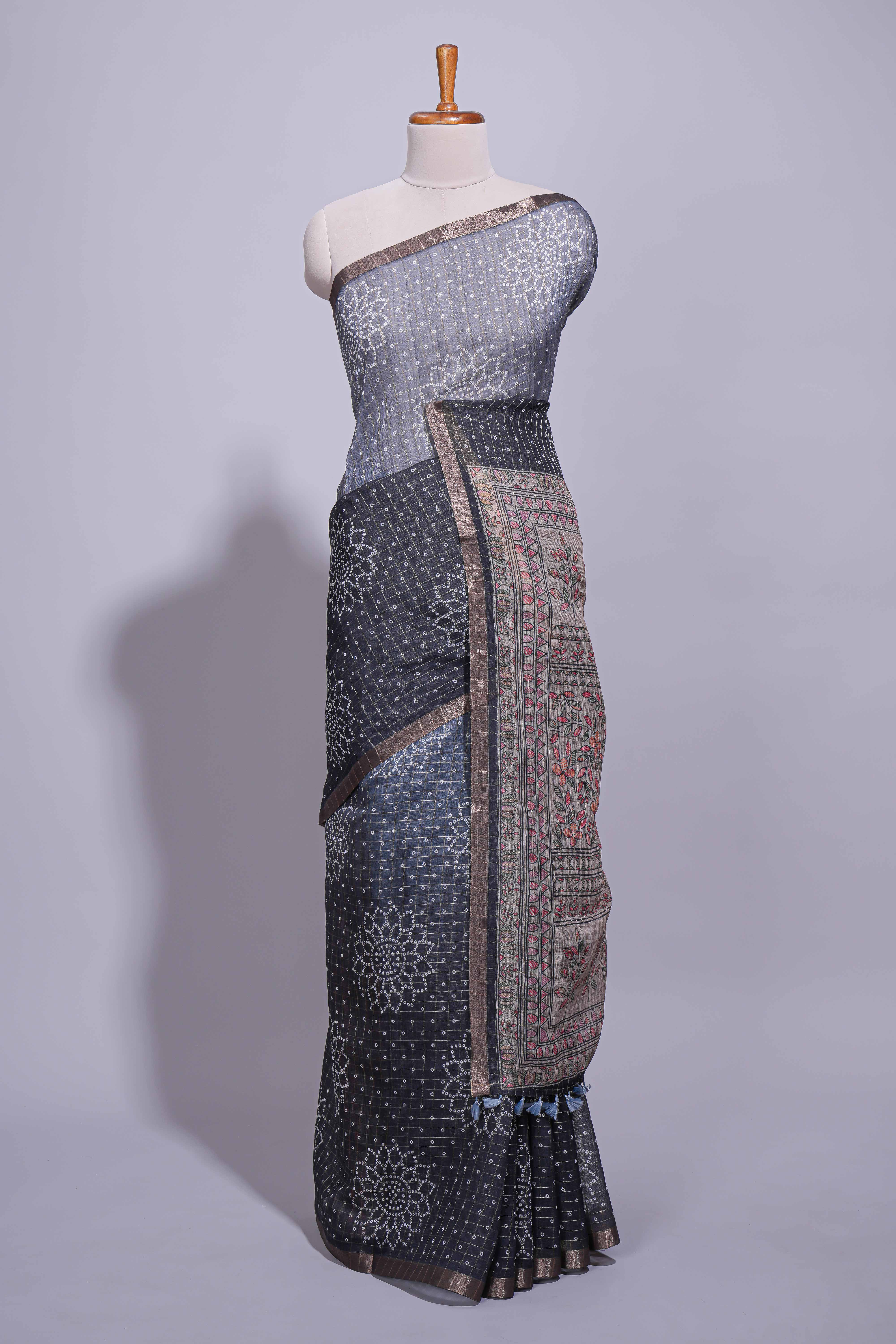 Elegant black and charcoal linen saree with geometric dotted motifs paired with a floral printed pallu and contrast border with tassel along with printed blouse