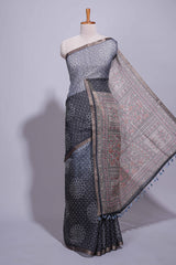 Elegant black and charcoal linen saree with geometric dotted motifs paired with a floral printed pallu and contrast border with tassel along with printed blouse