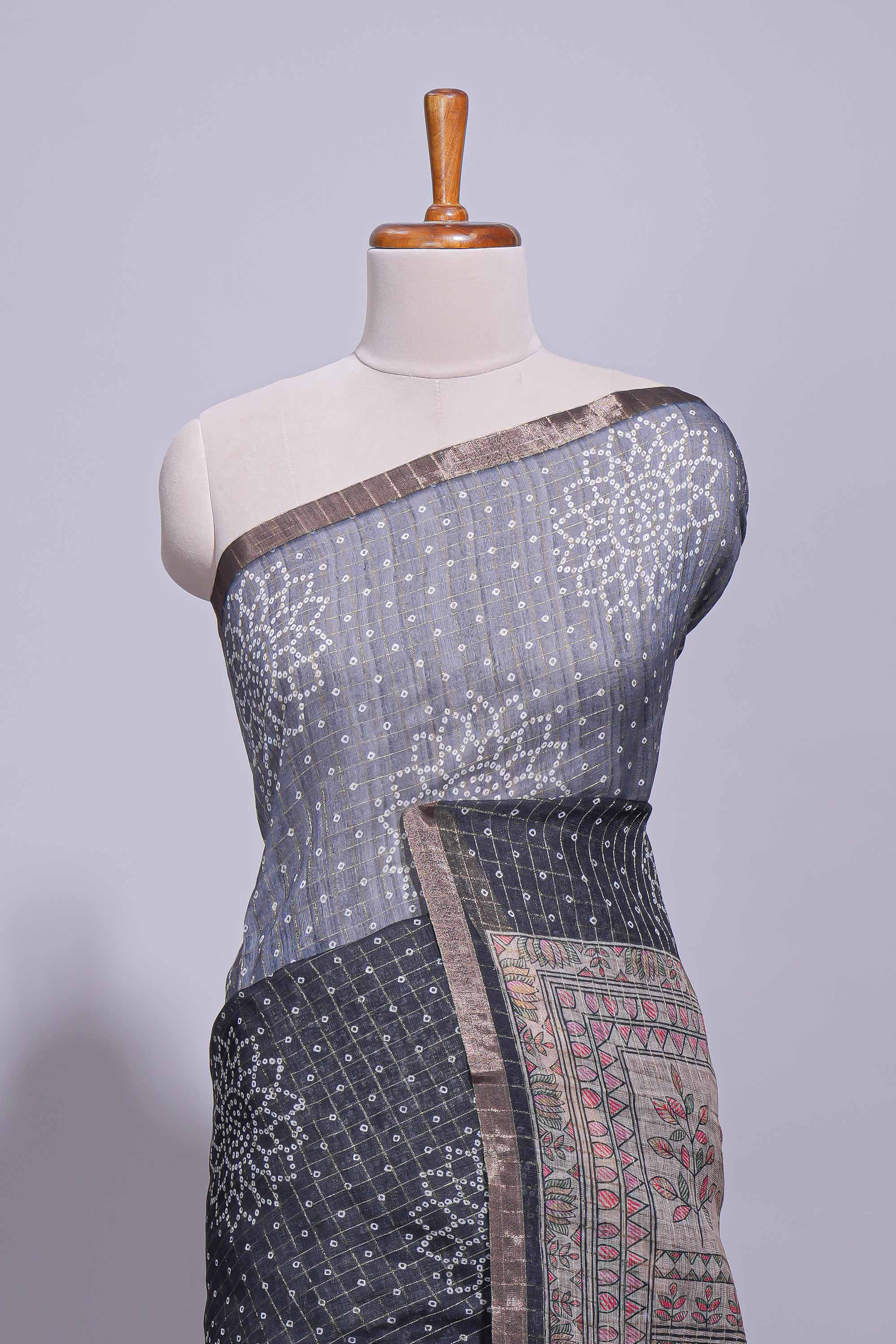 Elegant black and charcoal linen saree with geometric dotted motifs paired with a floral printed pallu and contrast border with tassel along with printed blouse