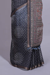Elegant black and charcoal linen saree with geometric dotted motifs paired with a floral printed pallu and contrast border with tassel along with printed blouse