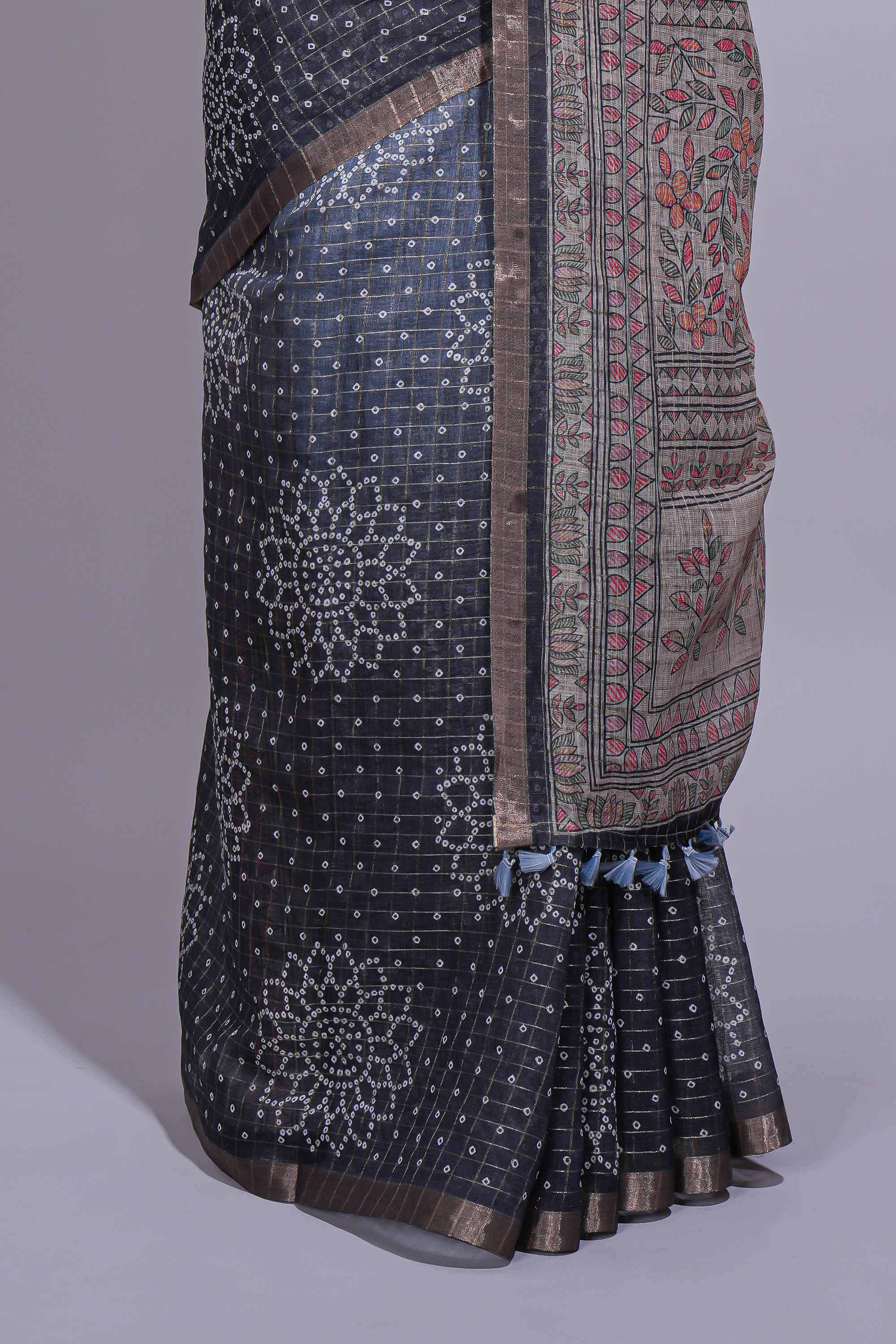 Elegant black and charcoal linen saree with geometric dotted motifs paired with a floral printed pallu and contrast border with tassel along with printed blouse