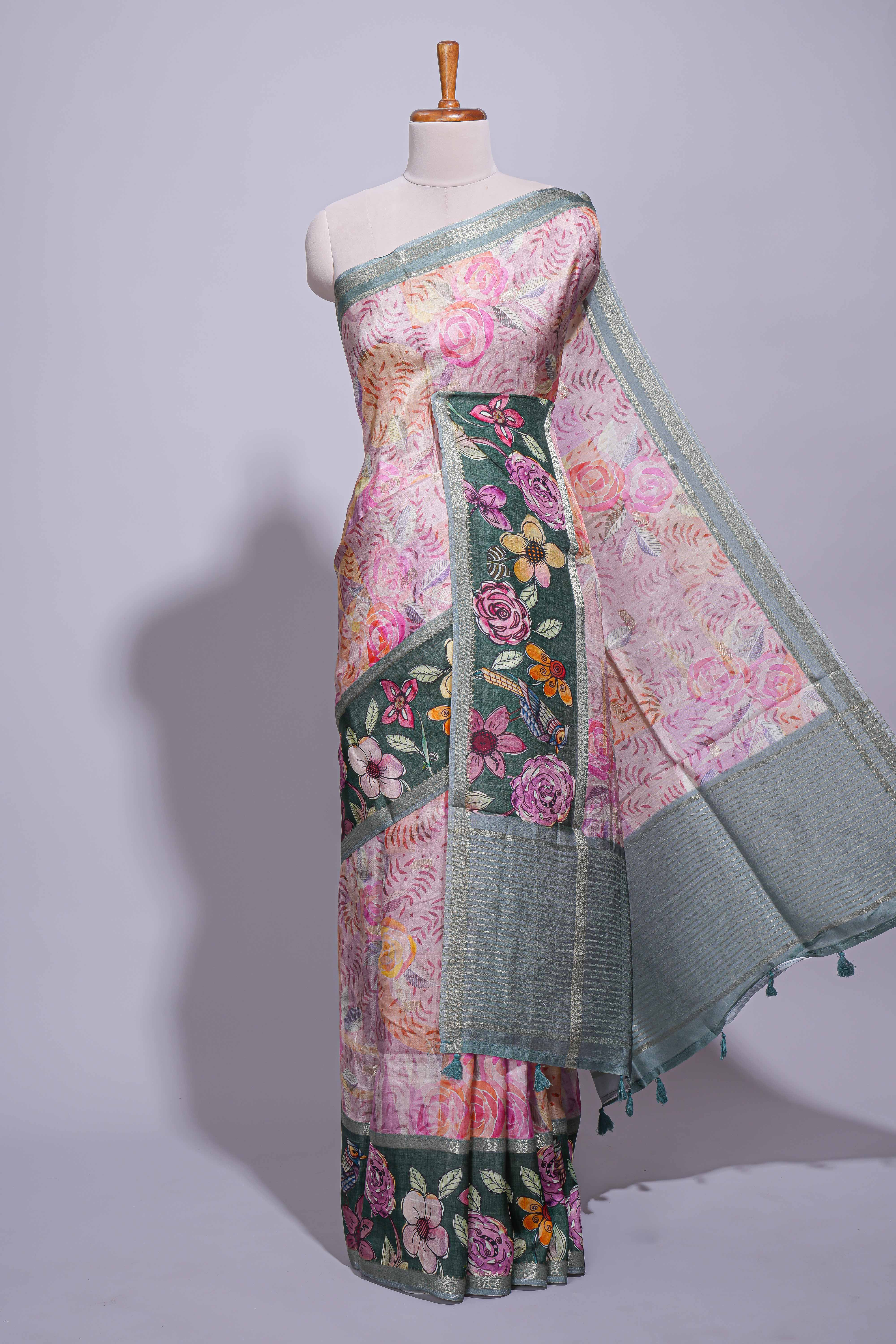 Soft pink linen saree with floral print highlighted with a contrast floral pallu and metallic zari border along with contrast blouse piece