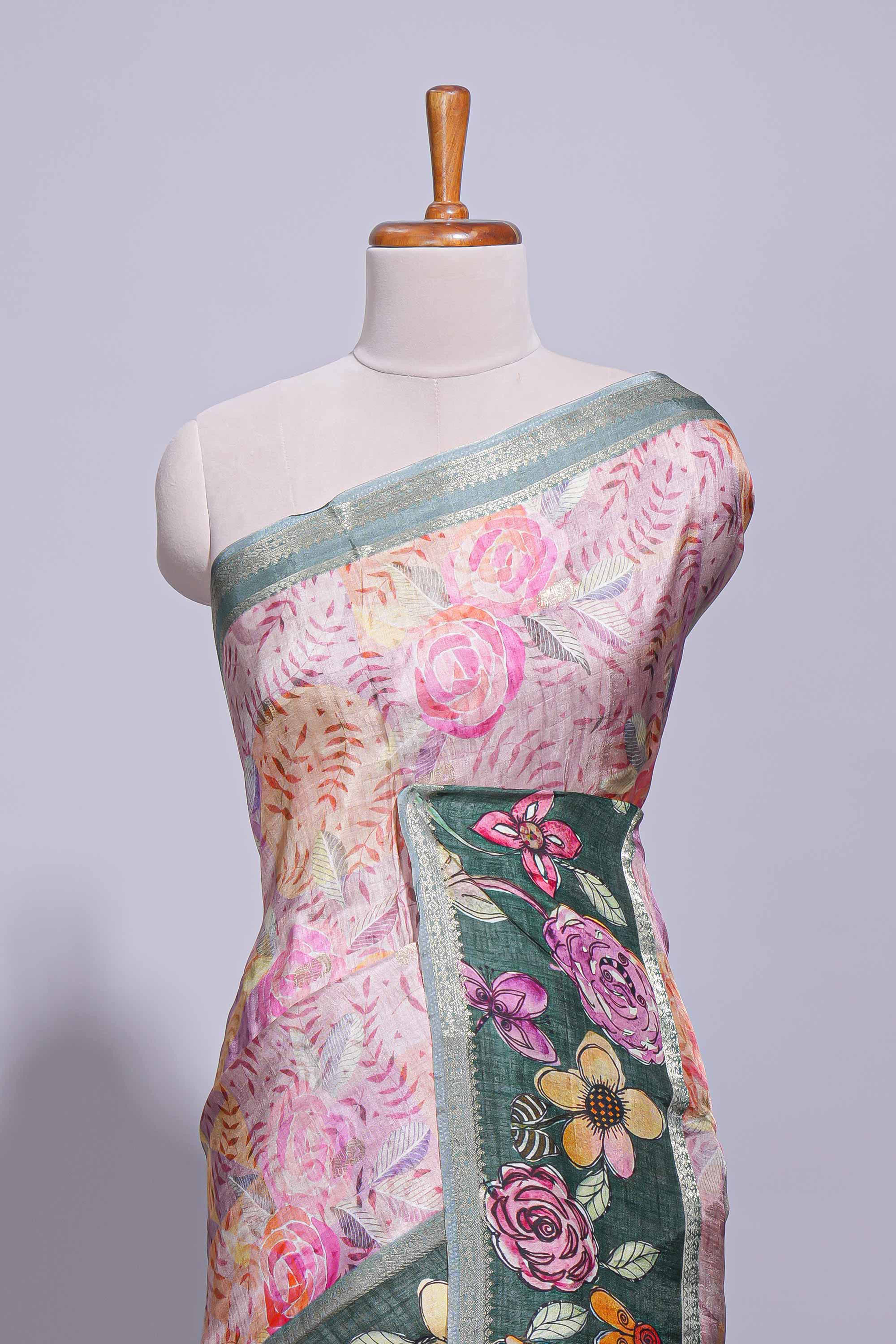 Soft pink linen saree with floral print highlighted with a contrast floral pallu and metallic zari border along with contrast blouse piece