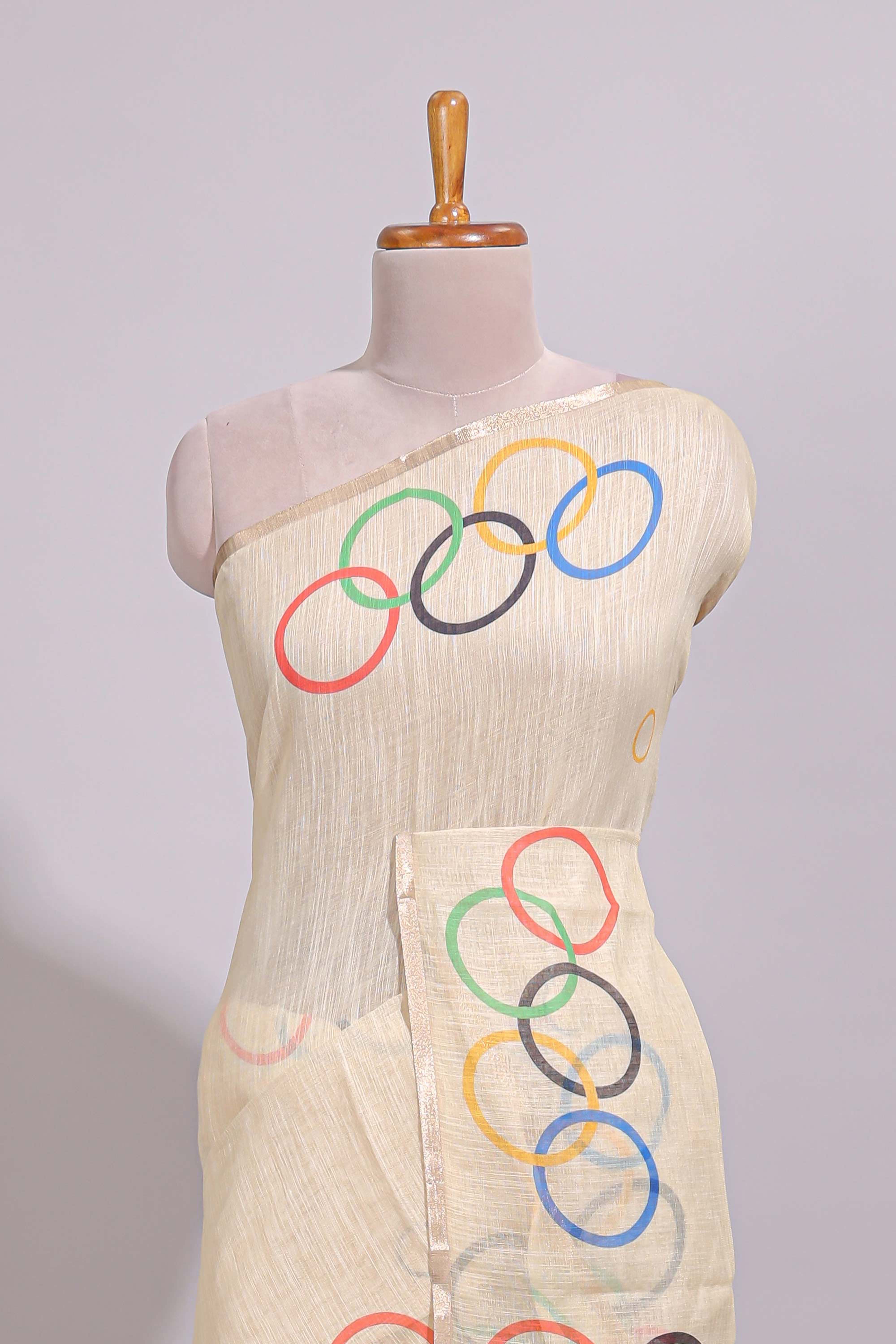 Cream olympic logo design linen cotton saree with self zari border and matching printed blouse
