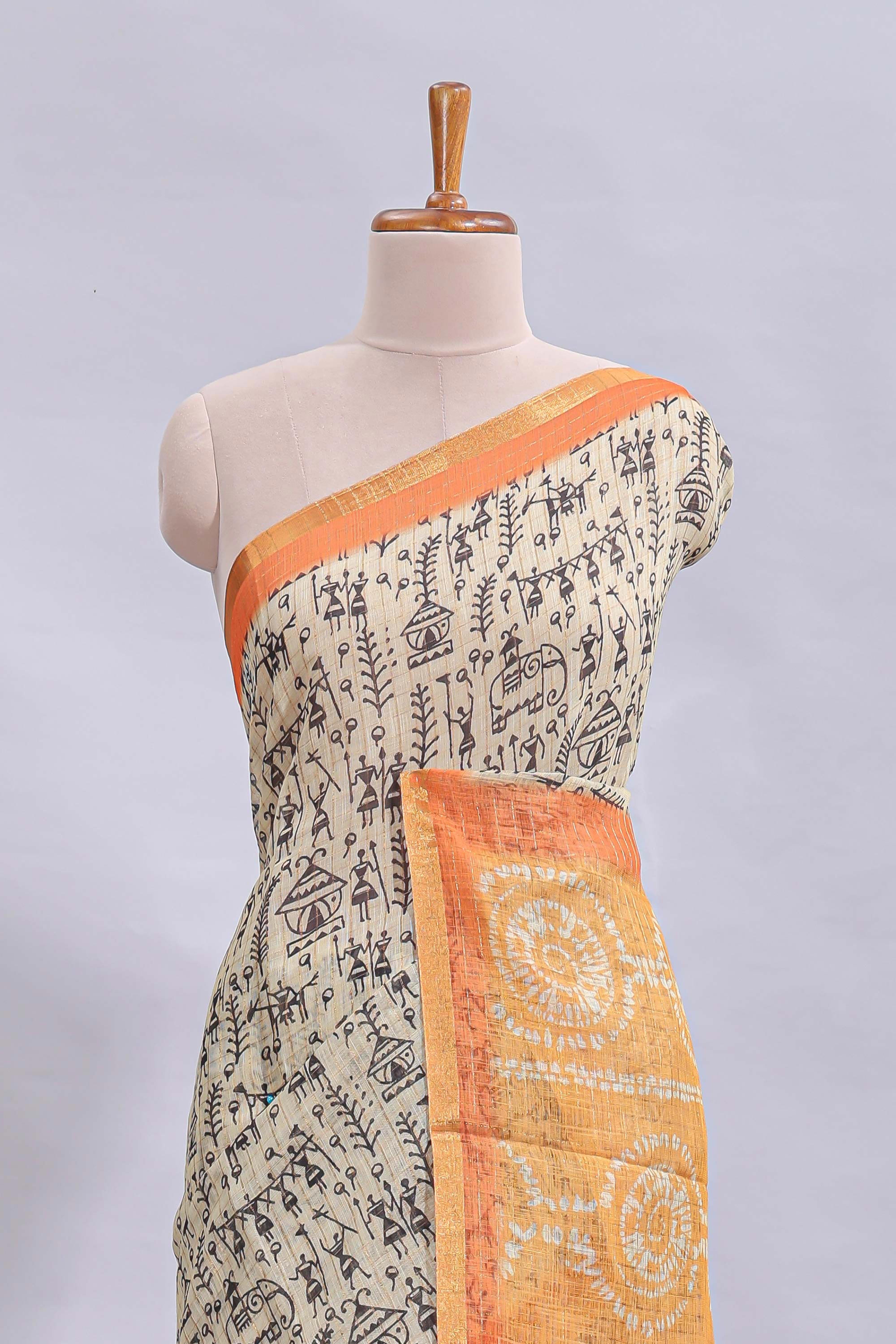 Beige tribal design warli print linen cotton saree with contrast orange zari border and warli design blouse